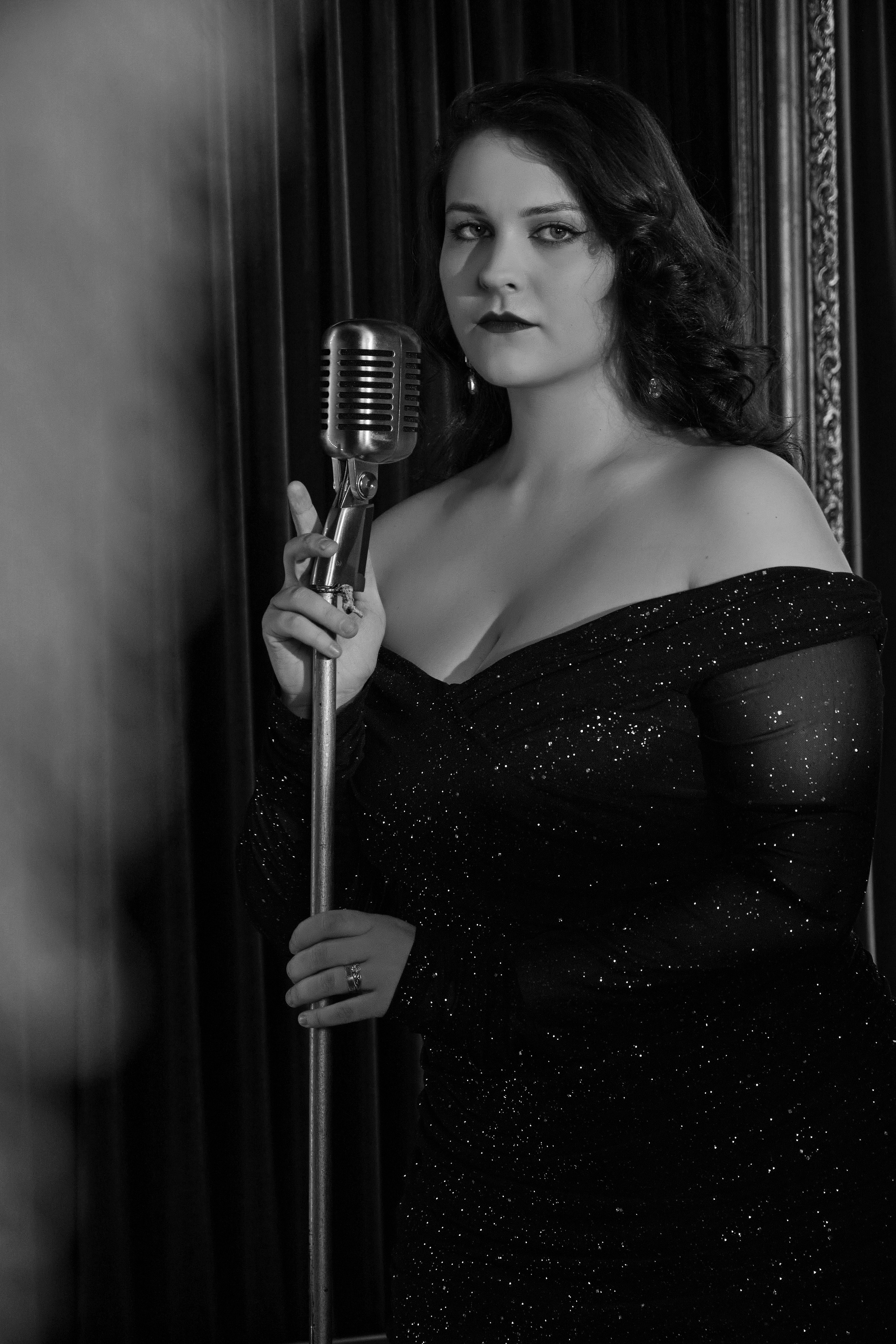 женский портрет в студии с микрофоном чёрно-белый