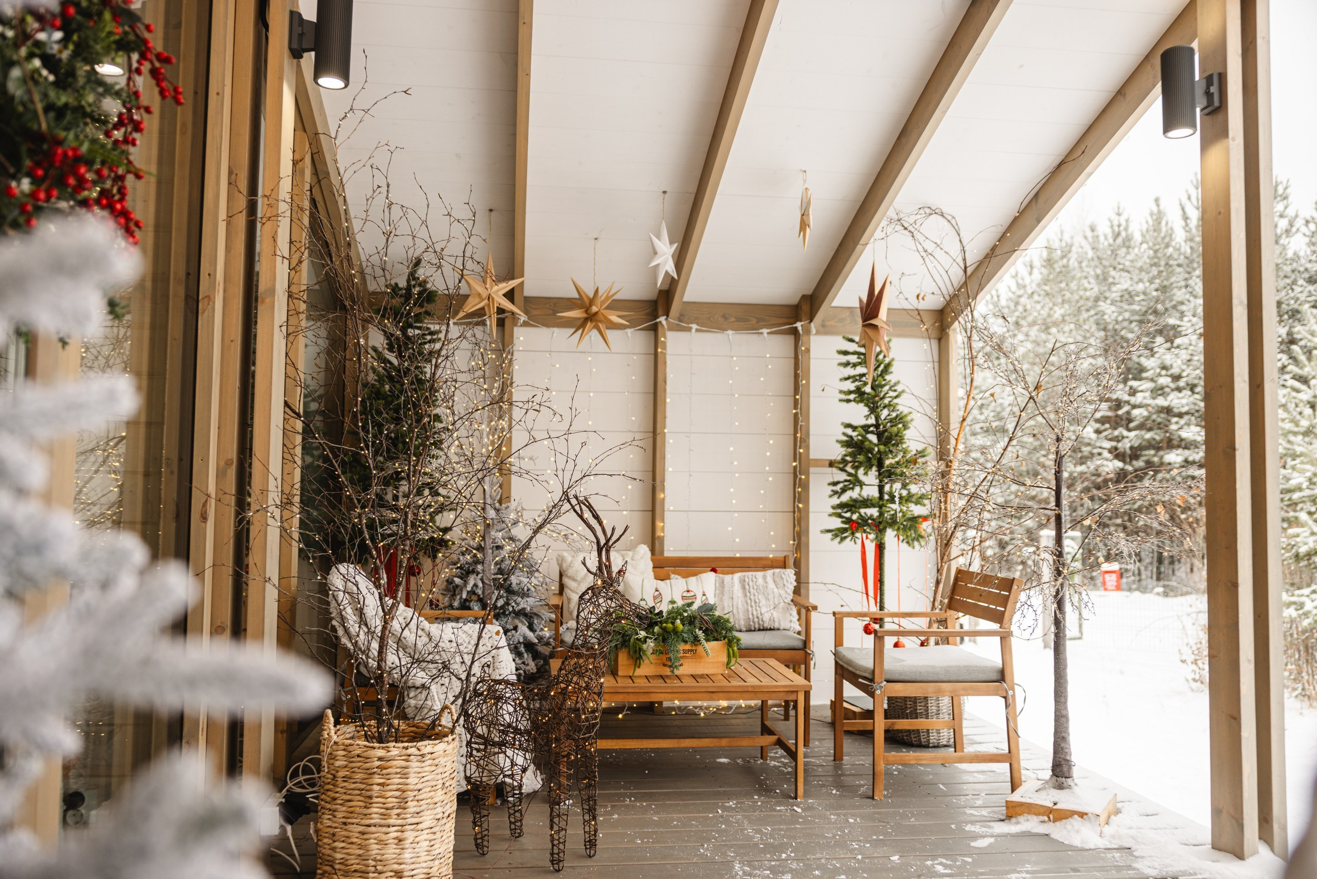 Фасад загородного дома 'Панорама' зимой, украшенный новогодними гирляндами и яркой иллюминацией