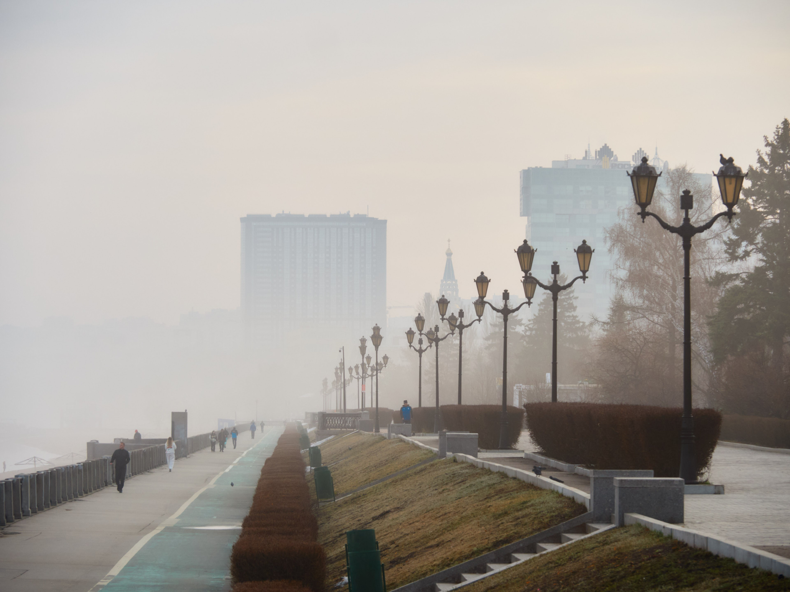 Крыши домов в густом утреннем тумане выглядят словно парящие в облаках