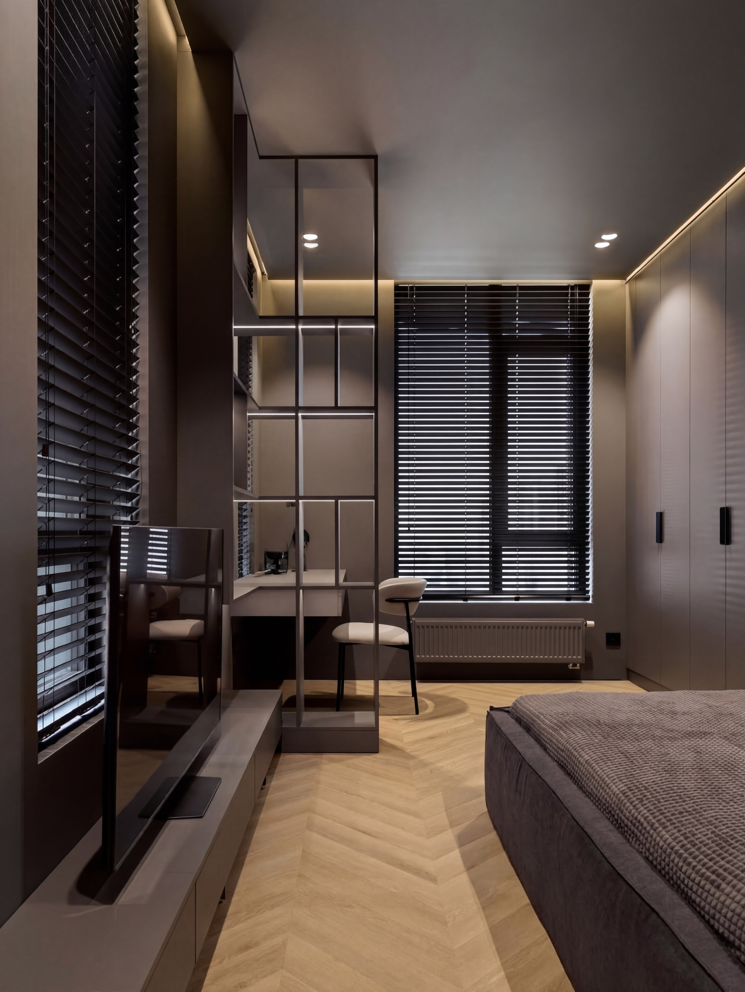 Рабочая зона в подростковой спальне от Валерии Котович: прозрачный стеллаж с подсветкой, лаконичный письменный стол, дизайнерское кресло и темные жалюзи на окнах.