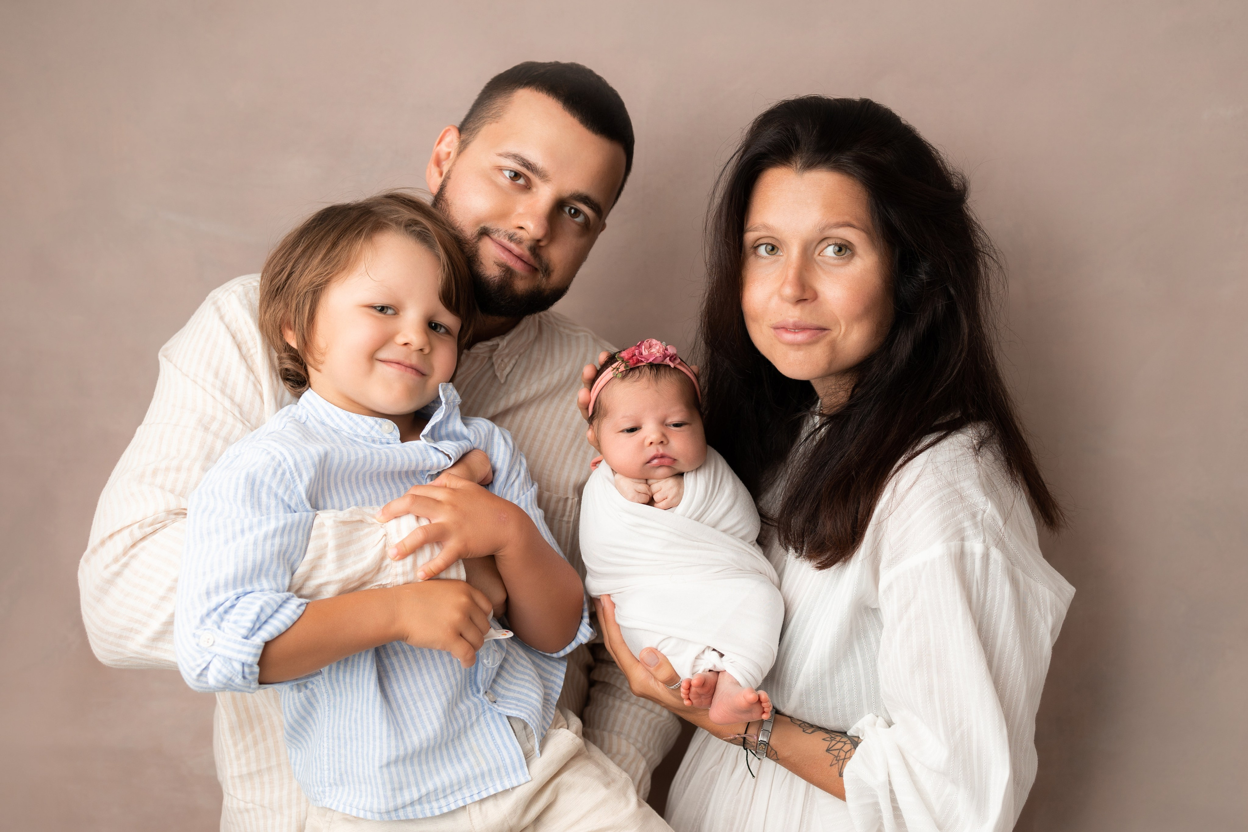семья из четырех человек с новорожденным малышом на руках 