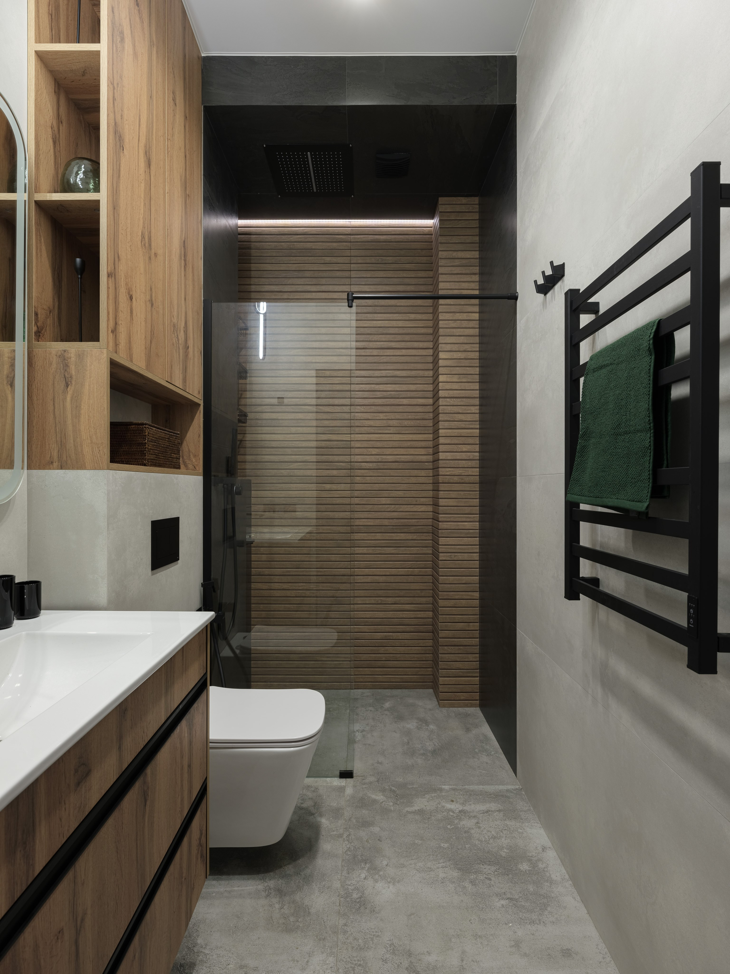 Современный санузел с душевой кабиной, отделкой под дерево и бетон, стеклянной перегородкой и чёрными деталями. Эстетика минимализма в проекте дизайнера Алины Дёровой, стилиста Натальи Якушевой, фотографа Сергея Денисенко.
