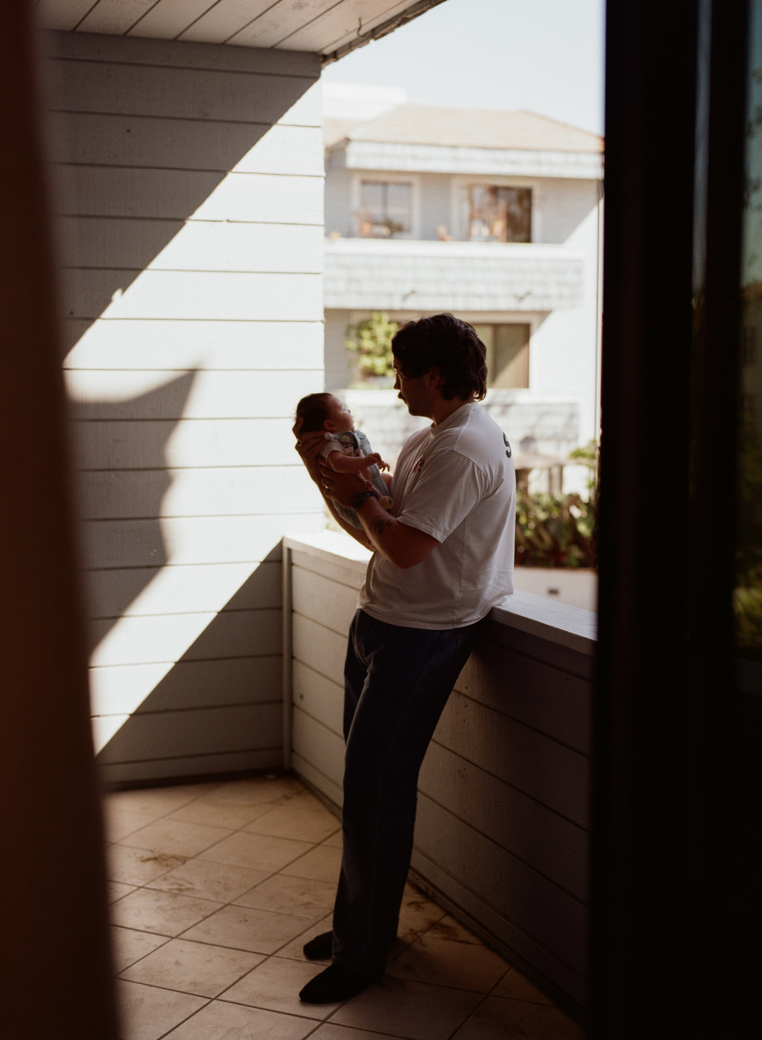 A quiet dad moment with his newborn baby girl on the balcony of their apartment