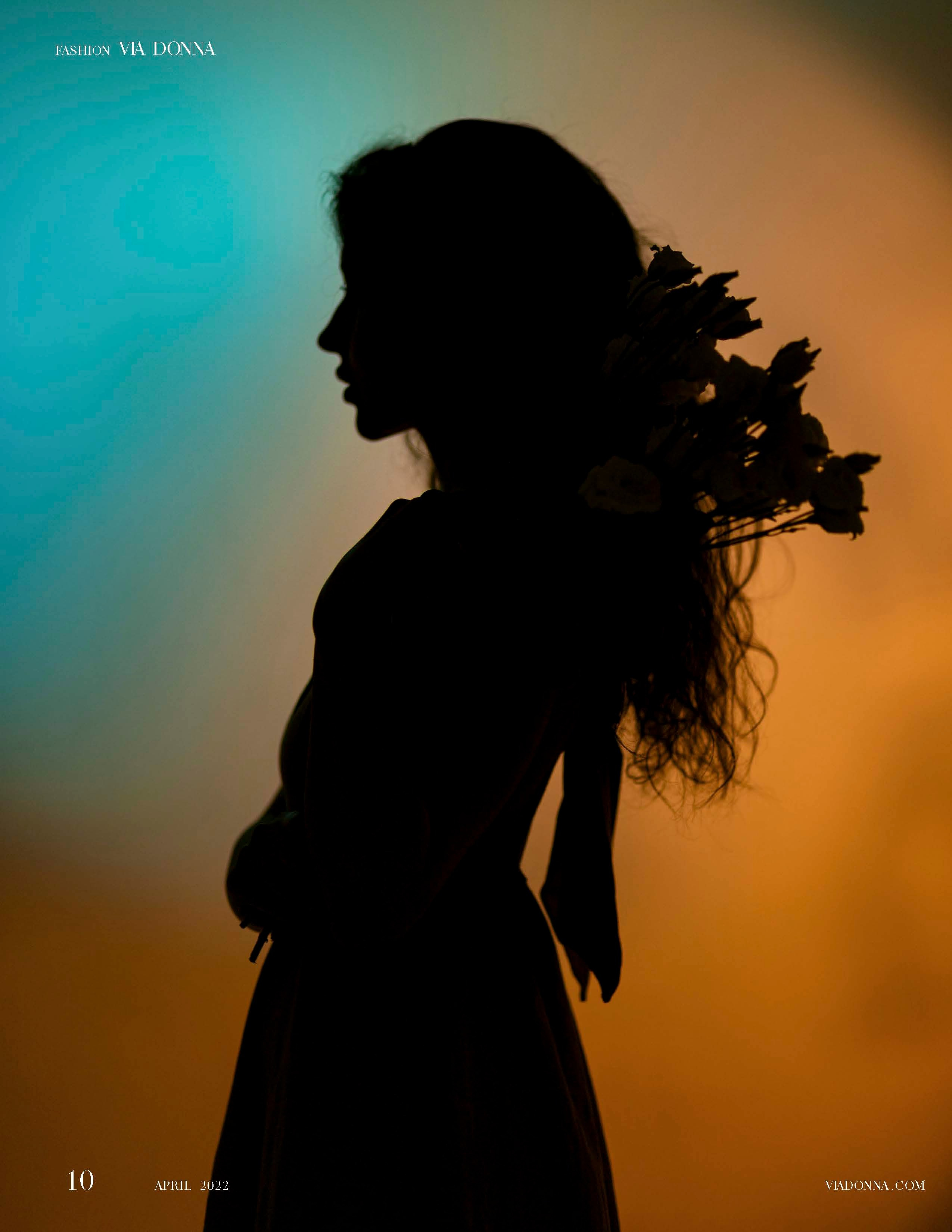 Силуэт женщины, нежно прижимающей к себе букет цветов, на ярком фоне теплых и холодных тонов передает ощущение красоты и спокойствия.