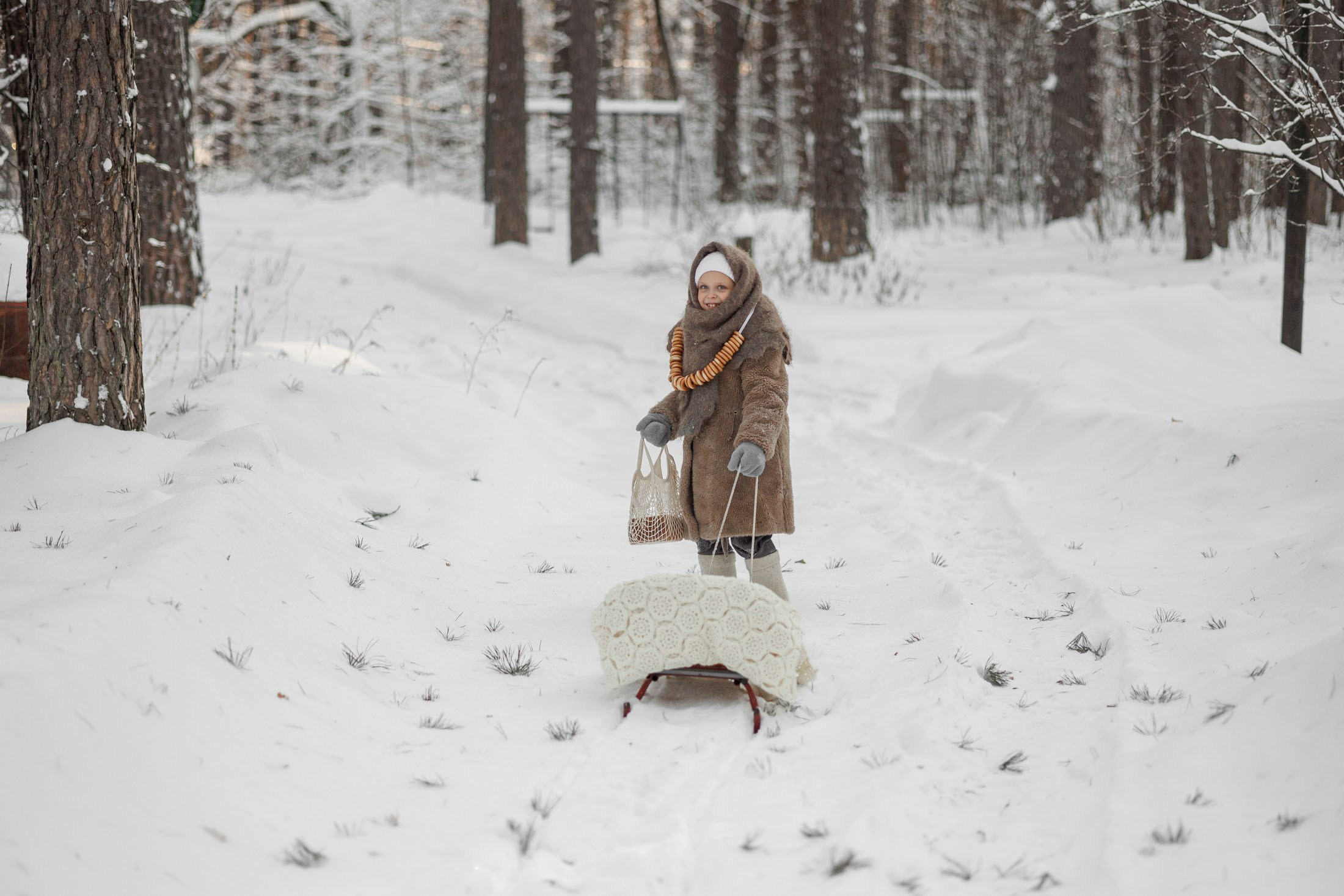 зимняя детская фотосессия в&nbsp;стиле советского времени. Маленькая девочка одета в&nbsp;шубу, валенки и&nbsp;пуховый платок