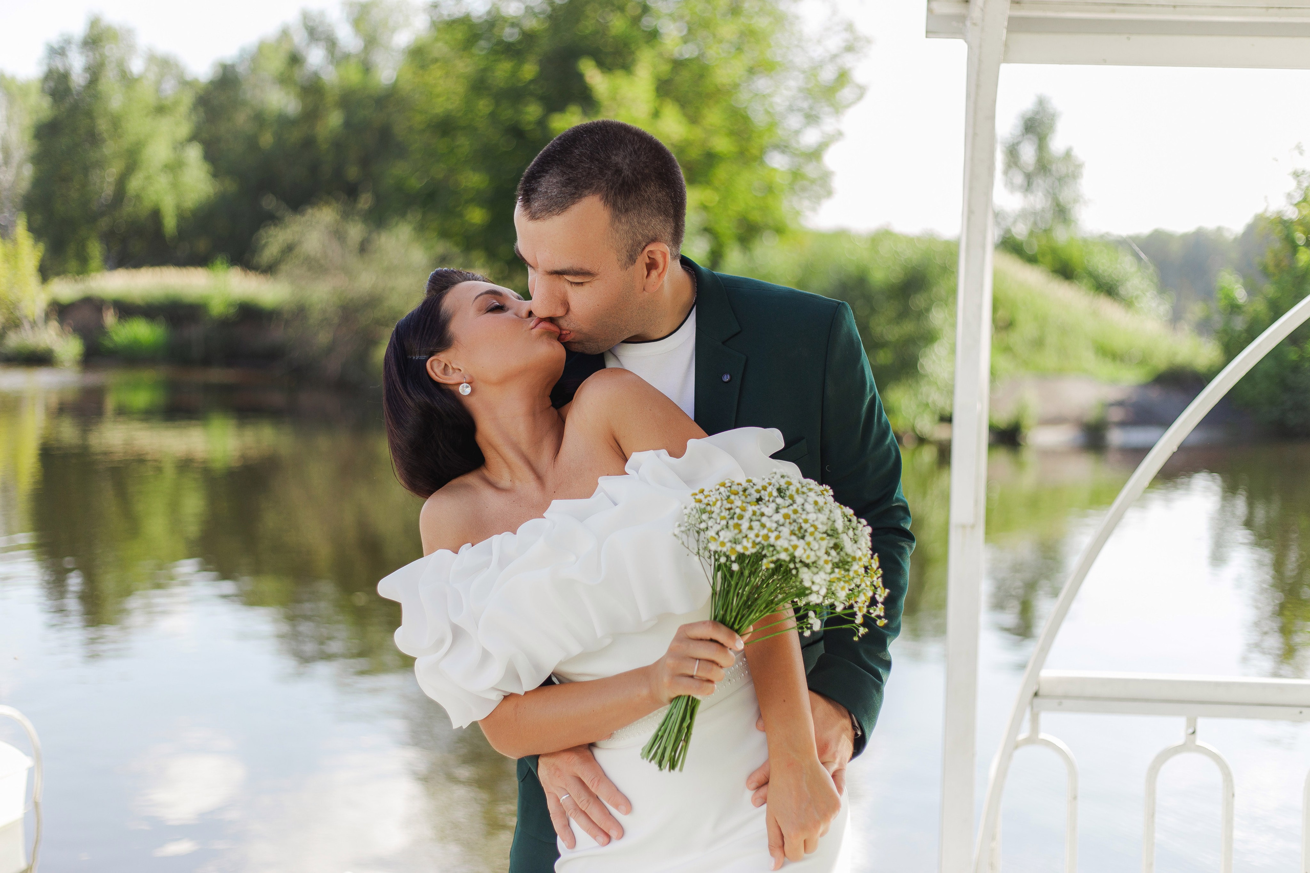 свадебное фото жениха и невесты на фоне водоема