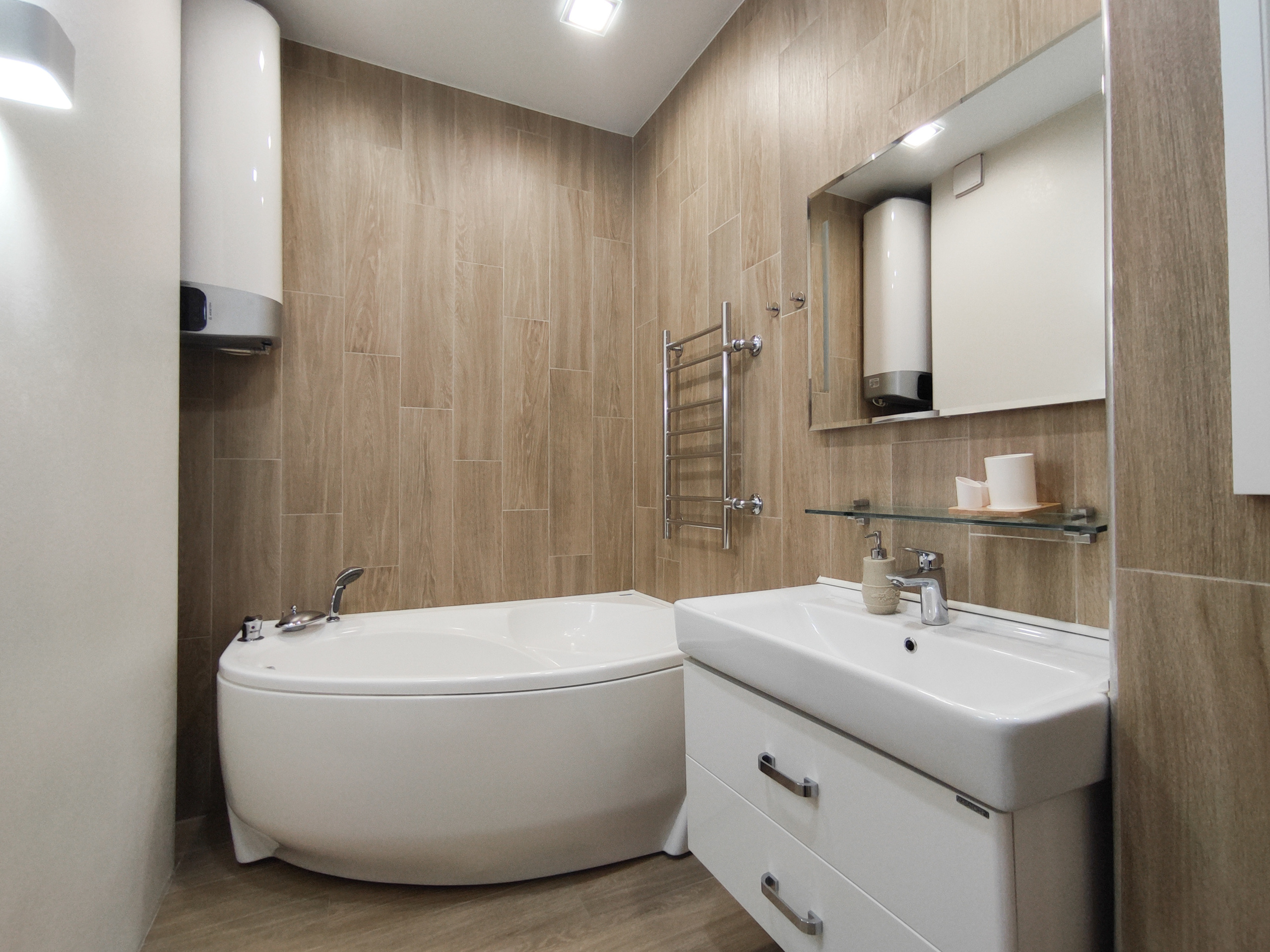 Красивая ванная комната с джакузи. Есть раковина и стильное зеркало.