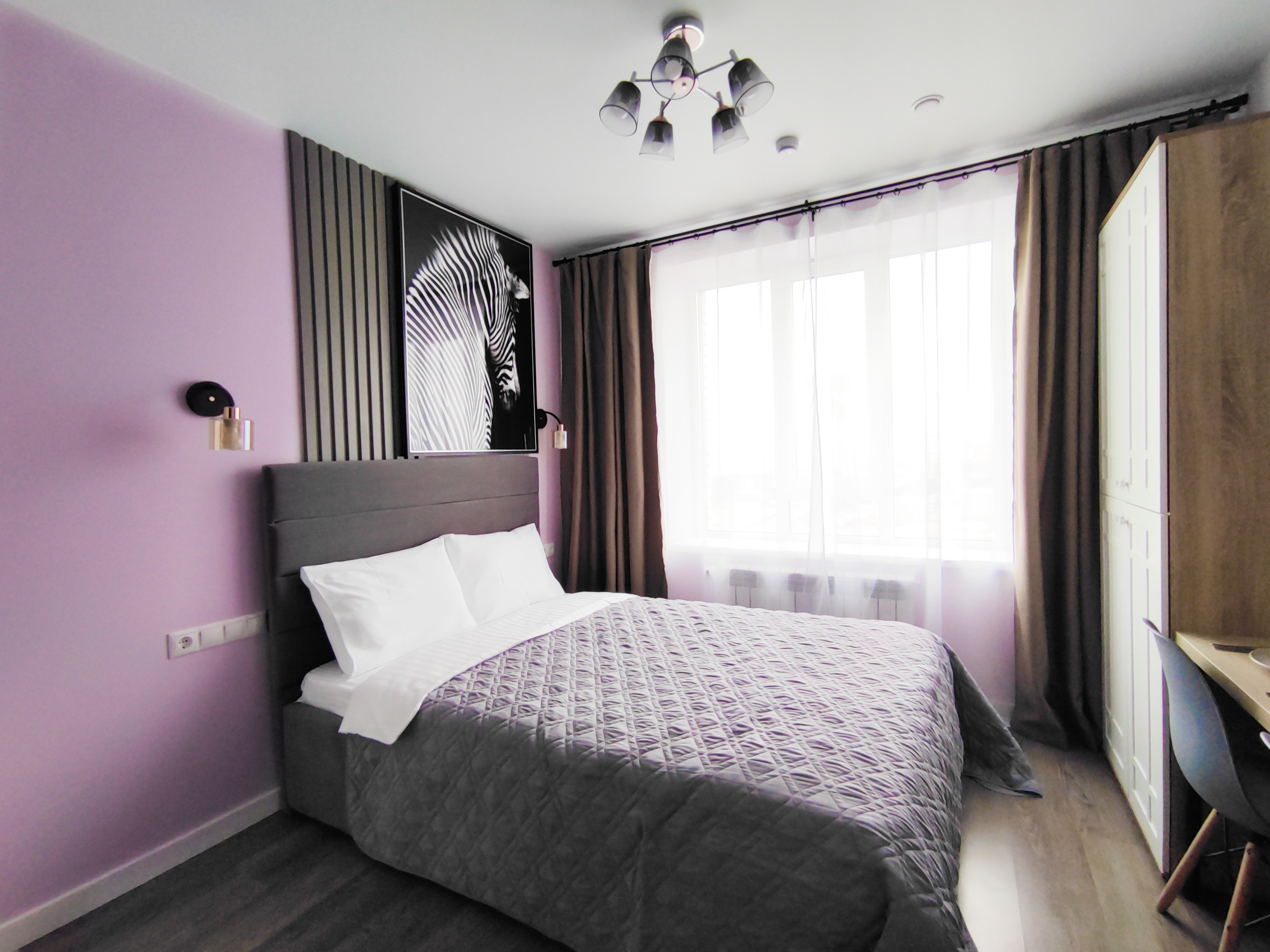 Интерьерная фотография квартиры с большой двухместной кроватью. Полностью мебелированная, светлая, ухоженная.