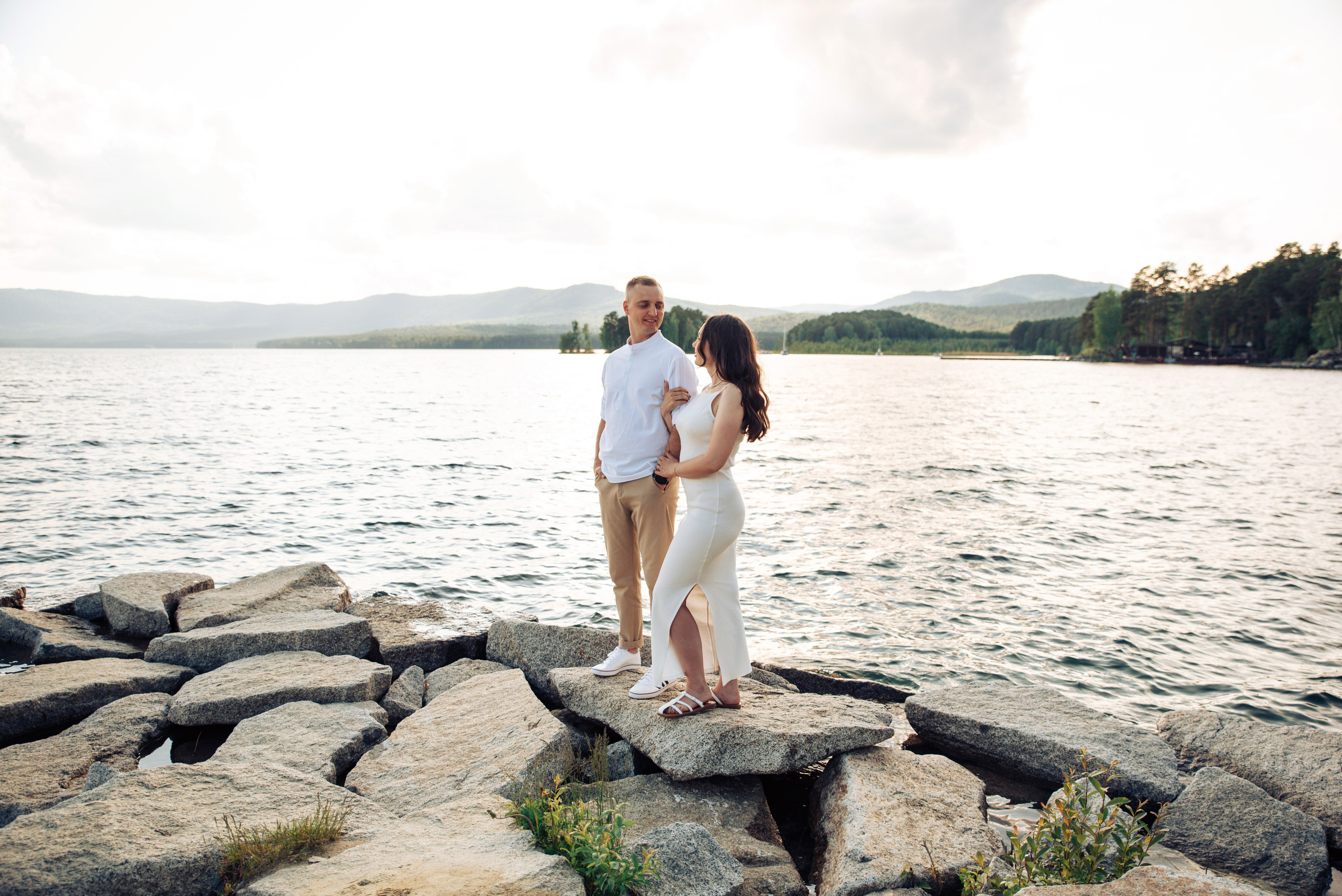 Семейная прогулка летом на берегу озера по пляжу