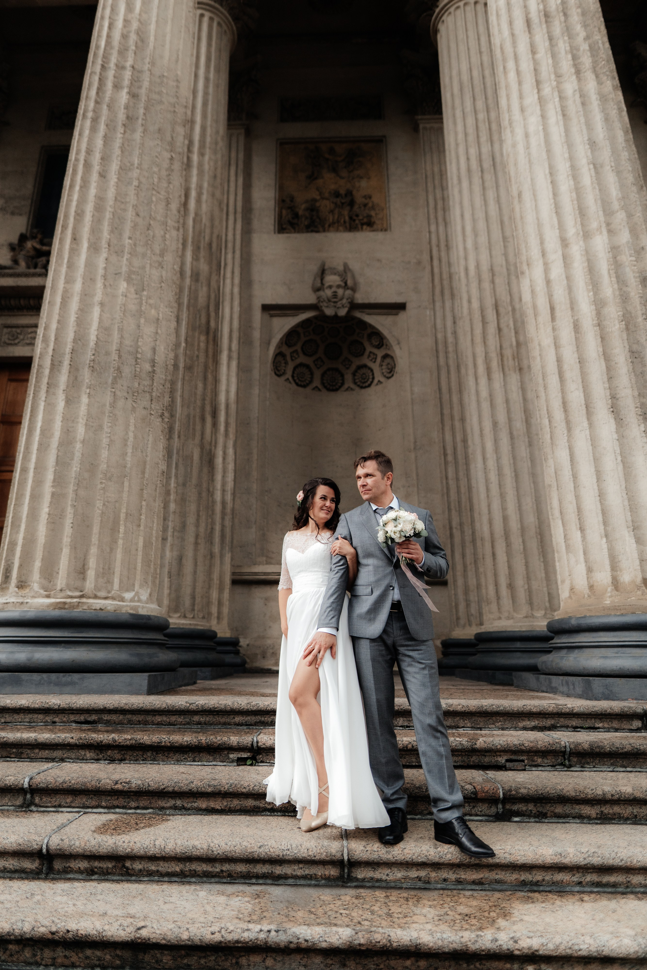 жених и невеста стоят на лестнице казанского собора