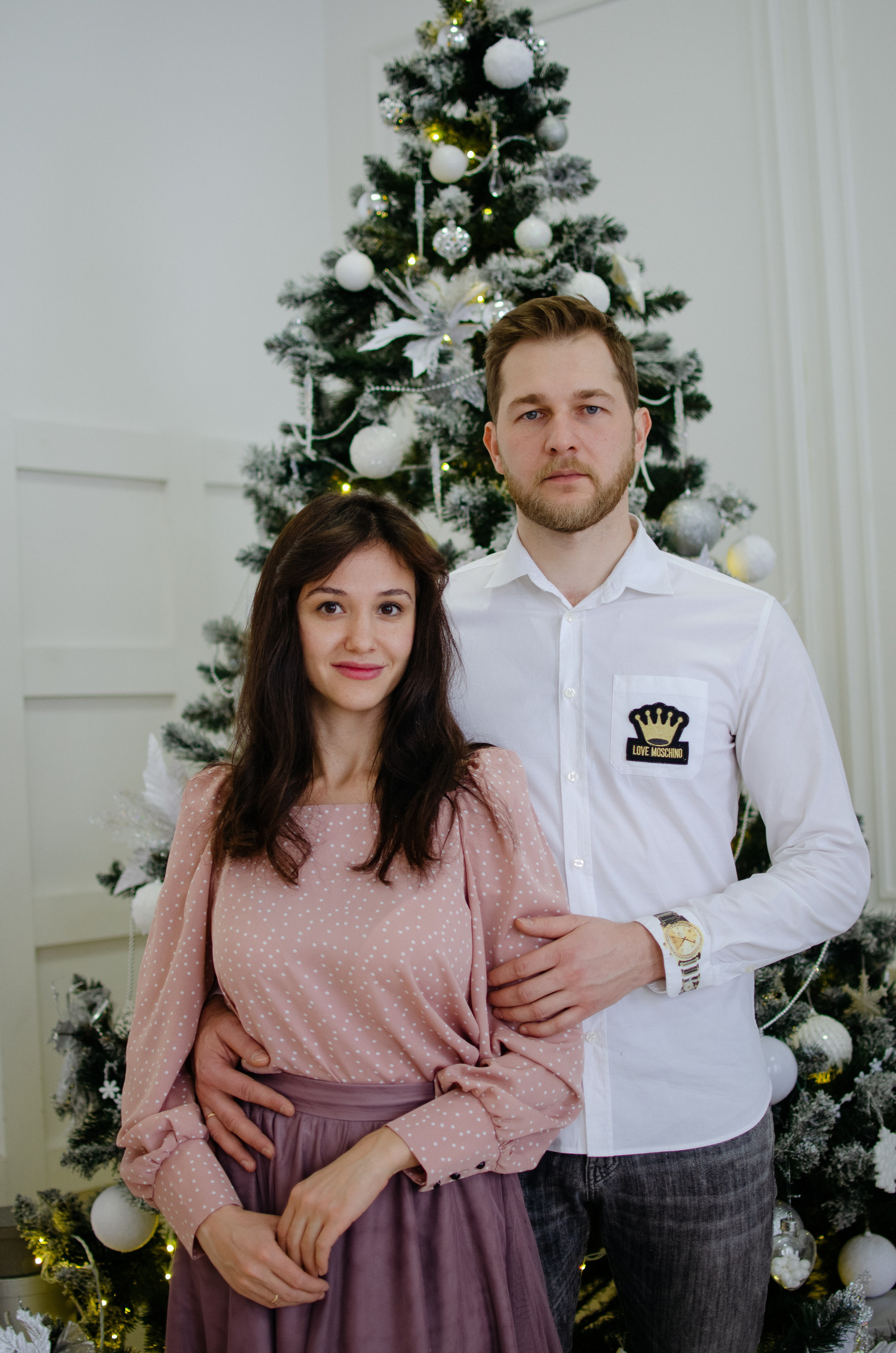 Муж и жена у ёлки на новогодней фотосессии