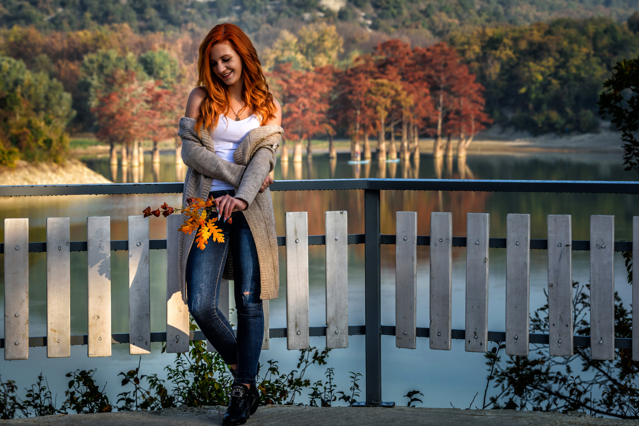 Девушка с рыжими волосами на фоне осеннего леса