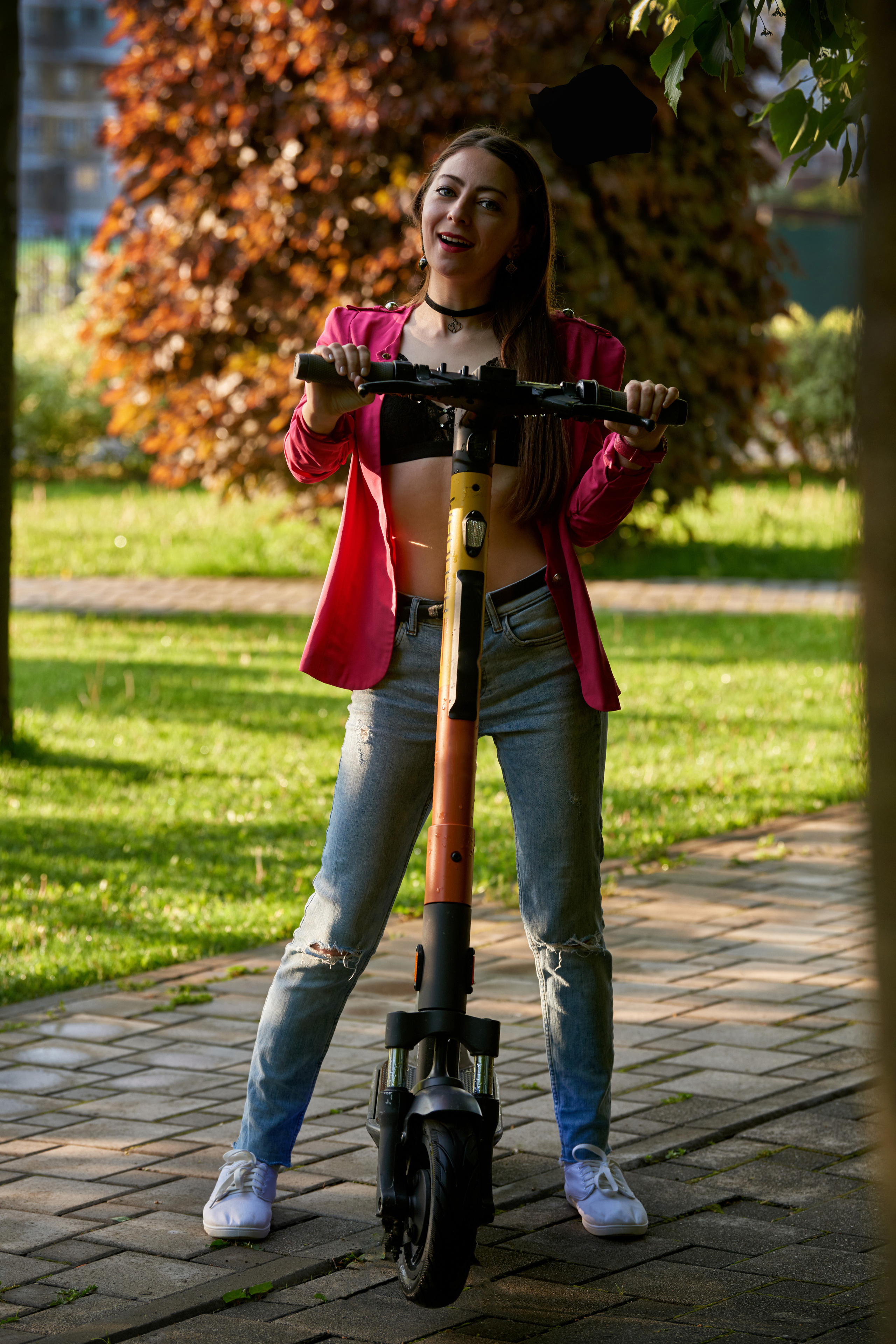 Девушка с самокатом в городском парке