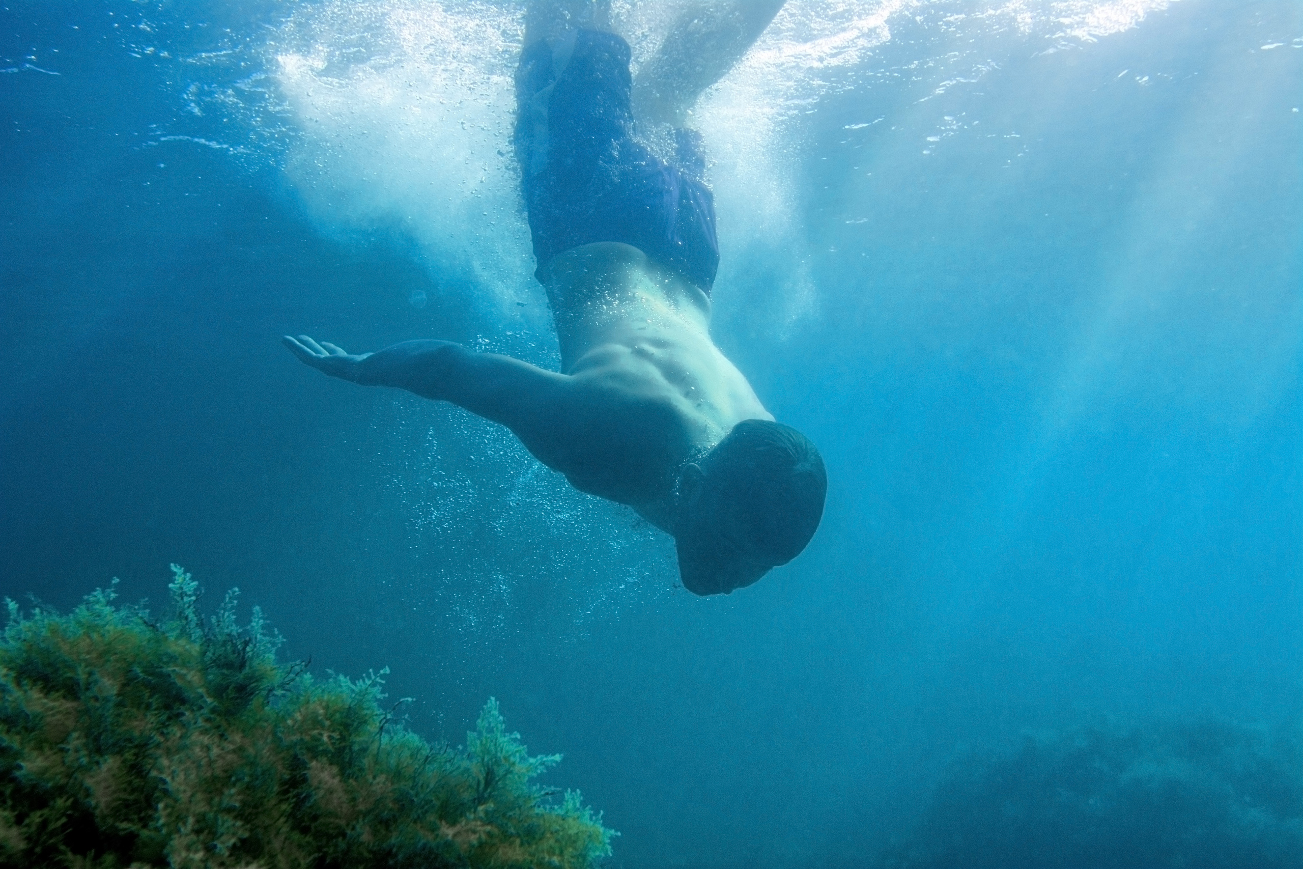 Парень, ныряющий под водой в море