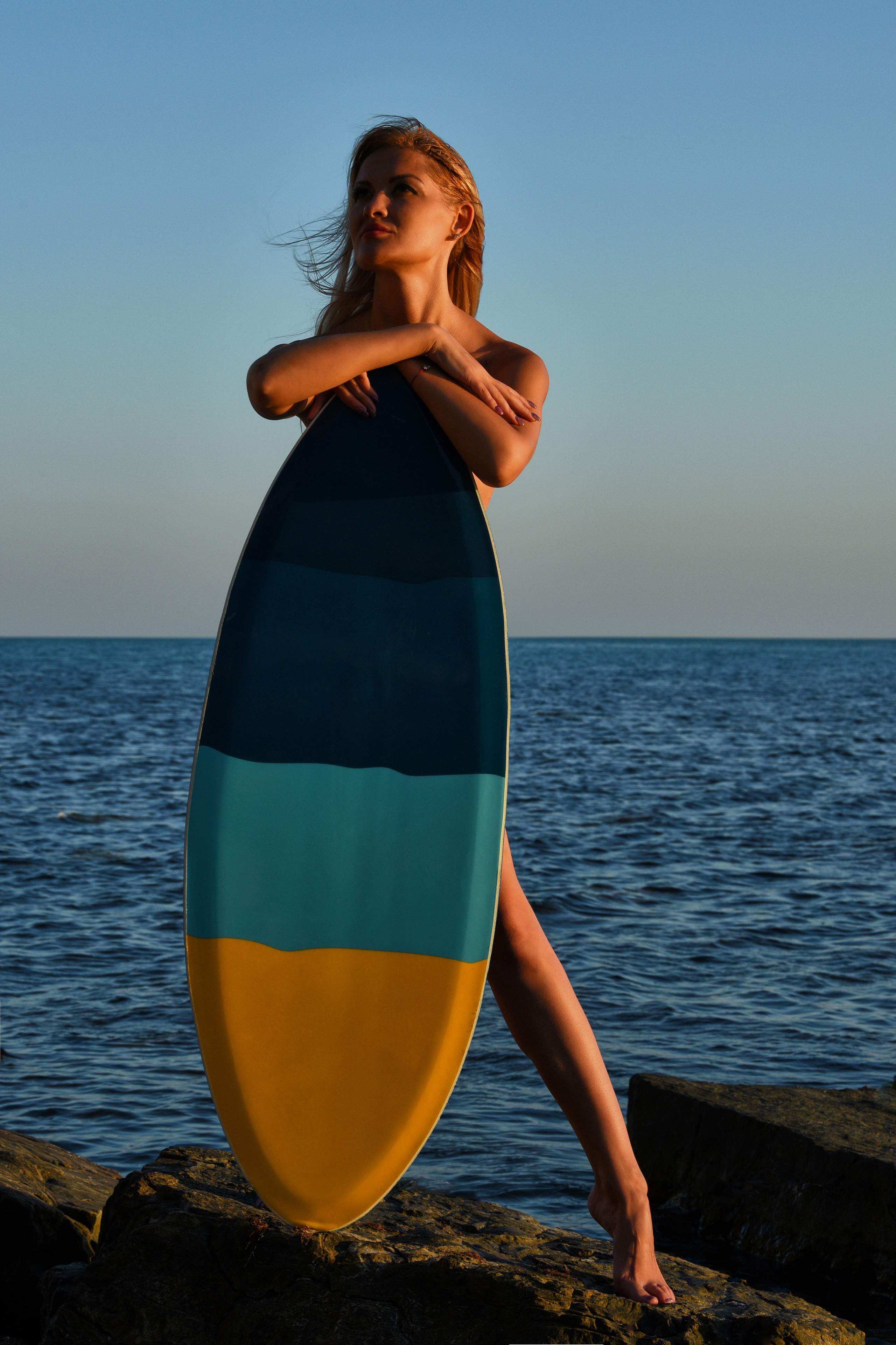 Девушка с серф бордом на берегу моря