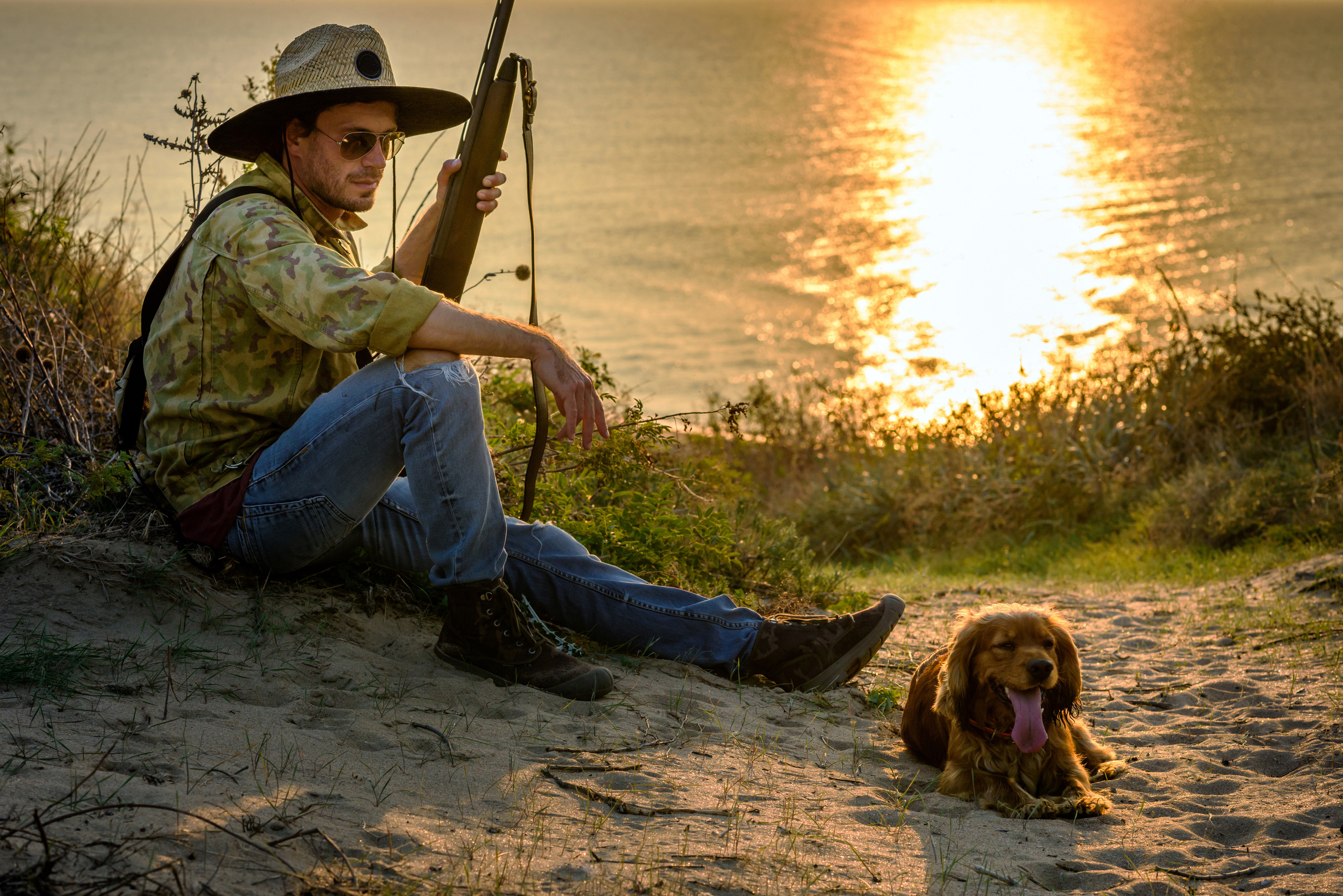 Охотник с ружьем и собакой на привале