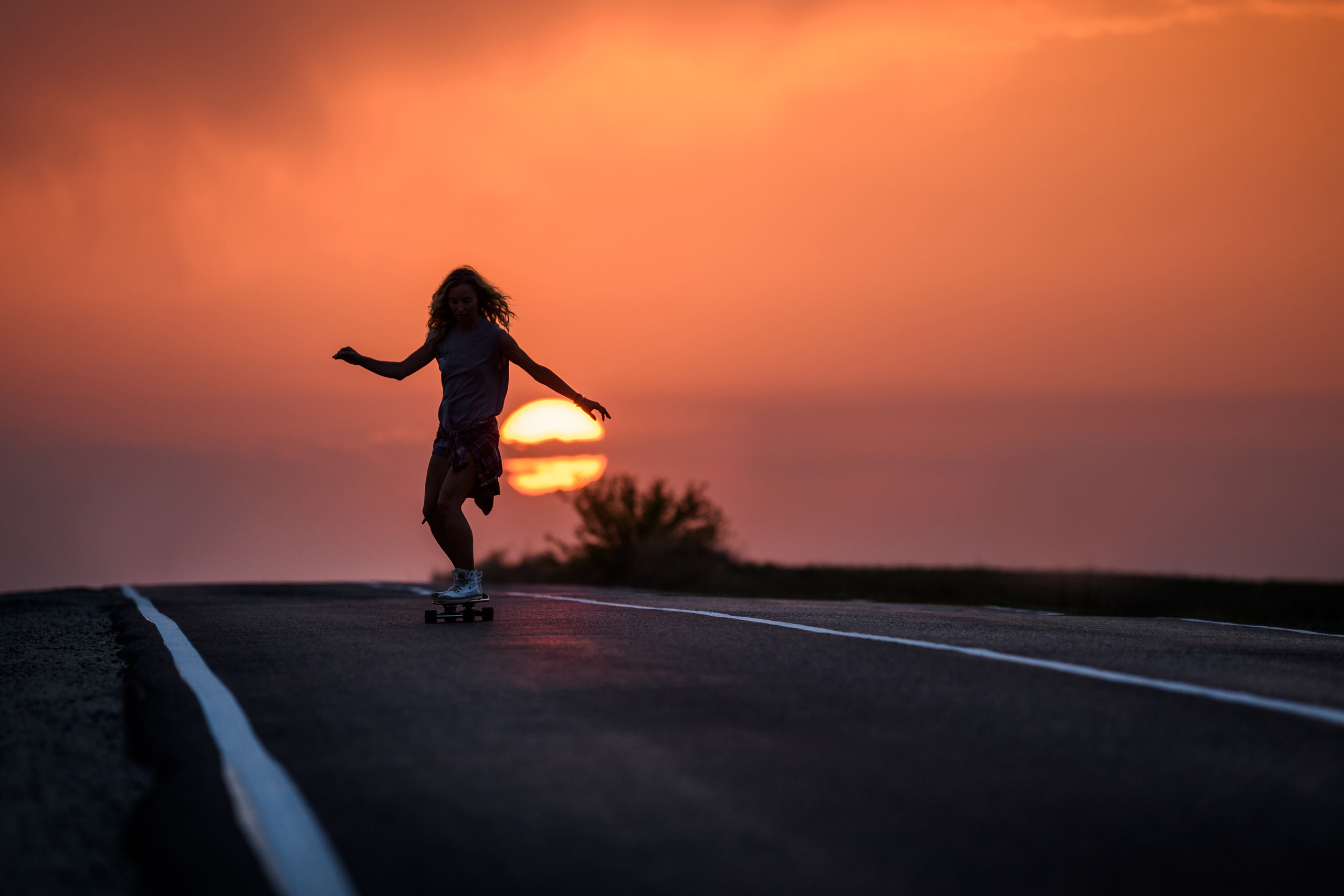 Девушка с Солнцем, катающаяся по дороге на скейте