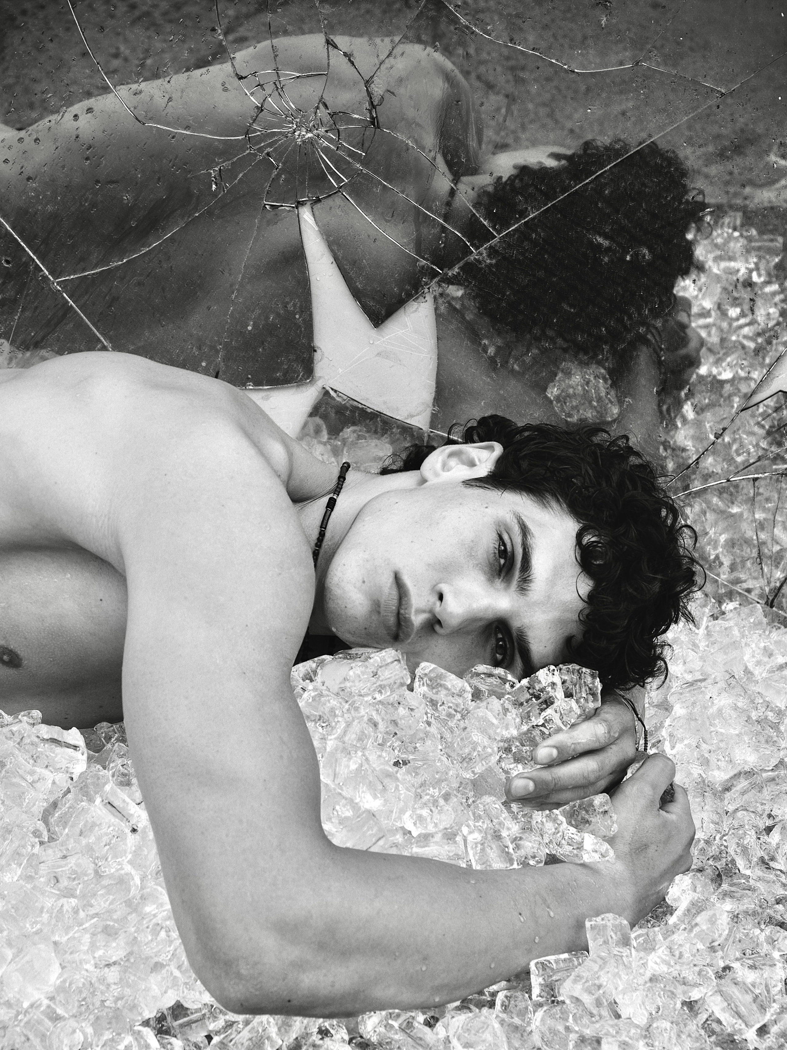 Black and white fashion portrait of Cem Kurttekin lying outdoors