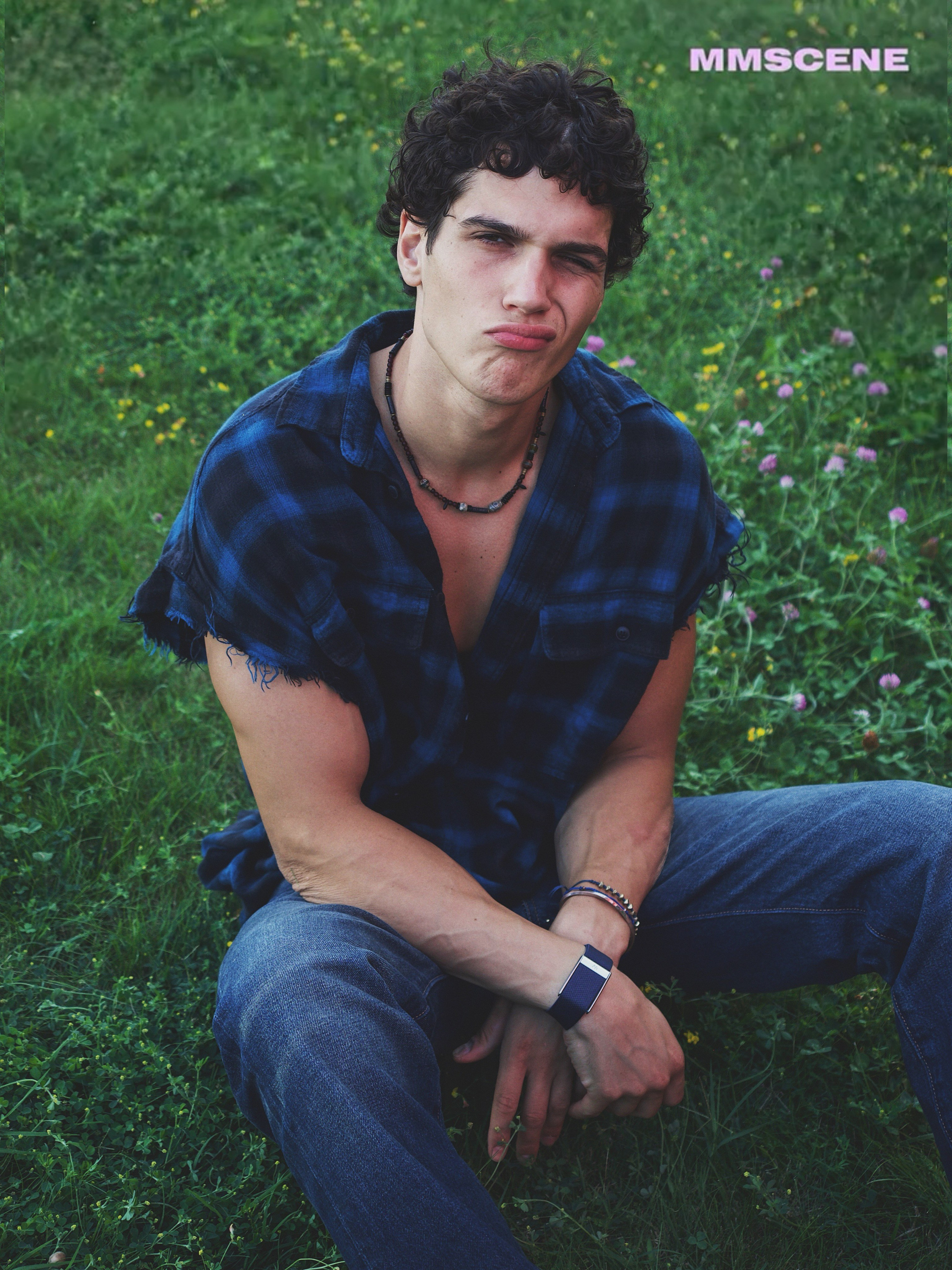Portrait of Cem Kurttekin sitting outdoors for the MMSCENE fashion editorial