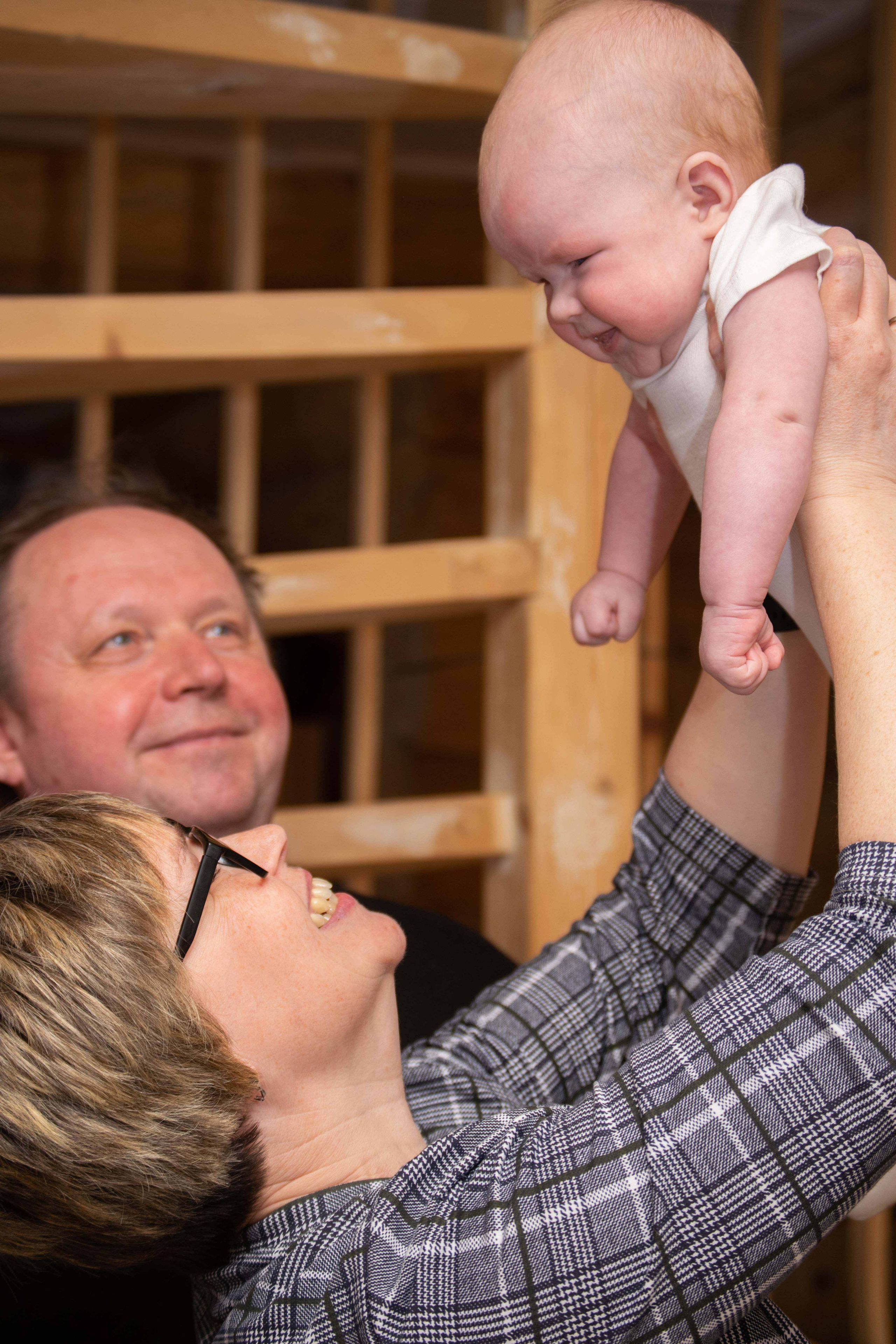 Бабушка и дедушка нянчатся с малышом. Семейная фотосессия в Карелии. 