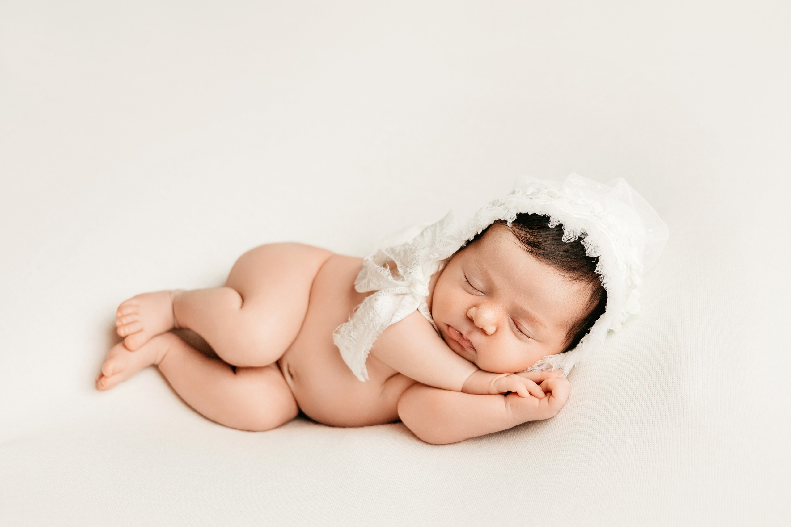 Малышка спит в шапочке на белом фоне
