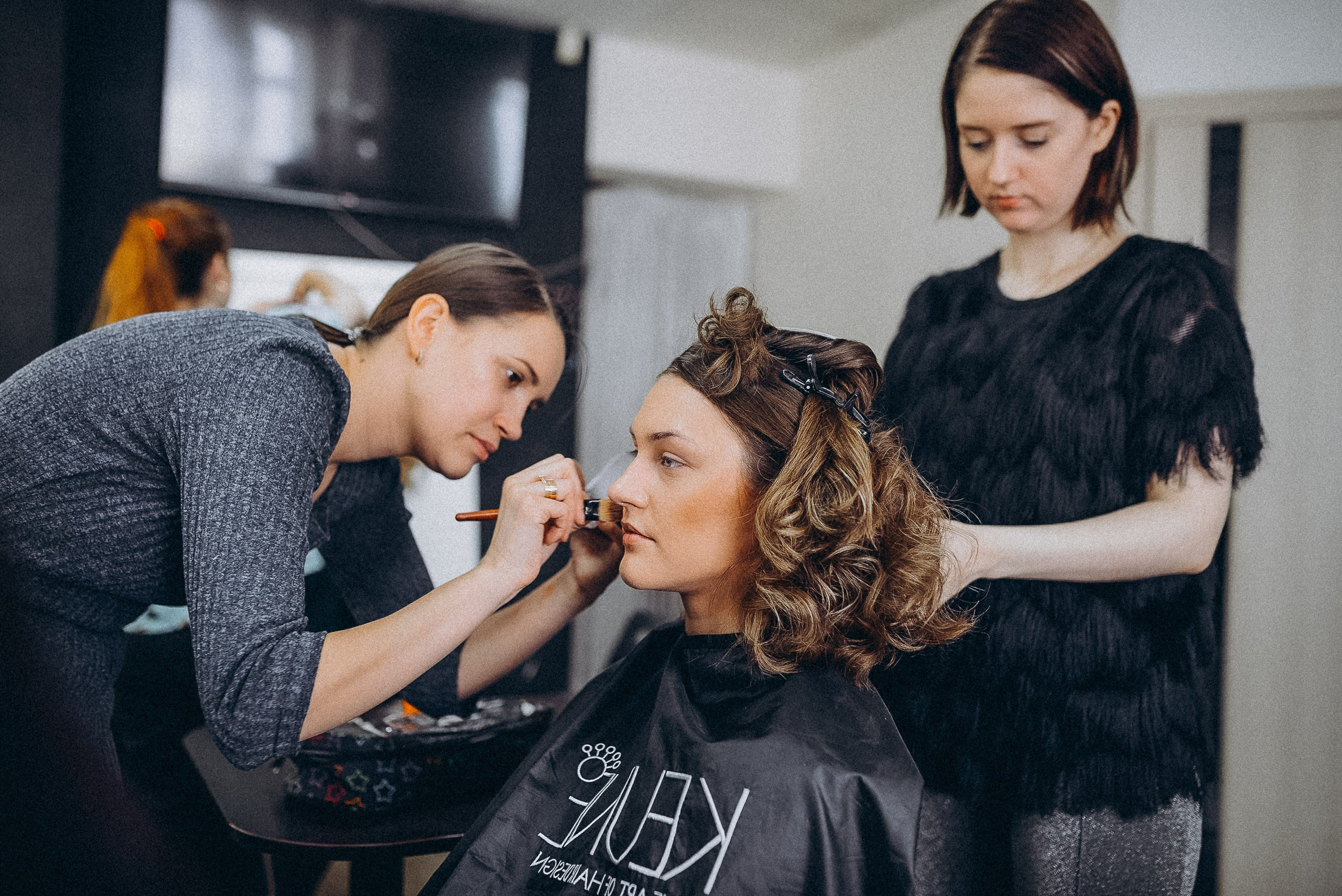 Детали образа: фиксация прически лаком, работа стилиста-парикмахера в гримерной.