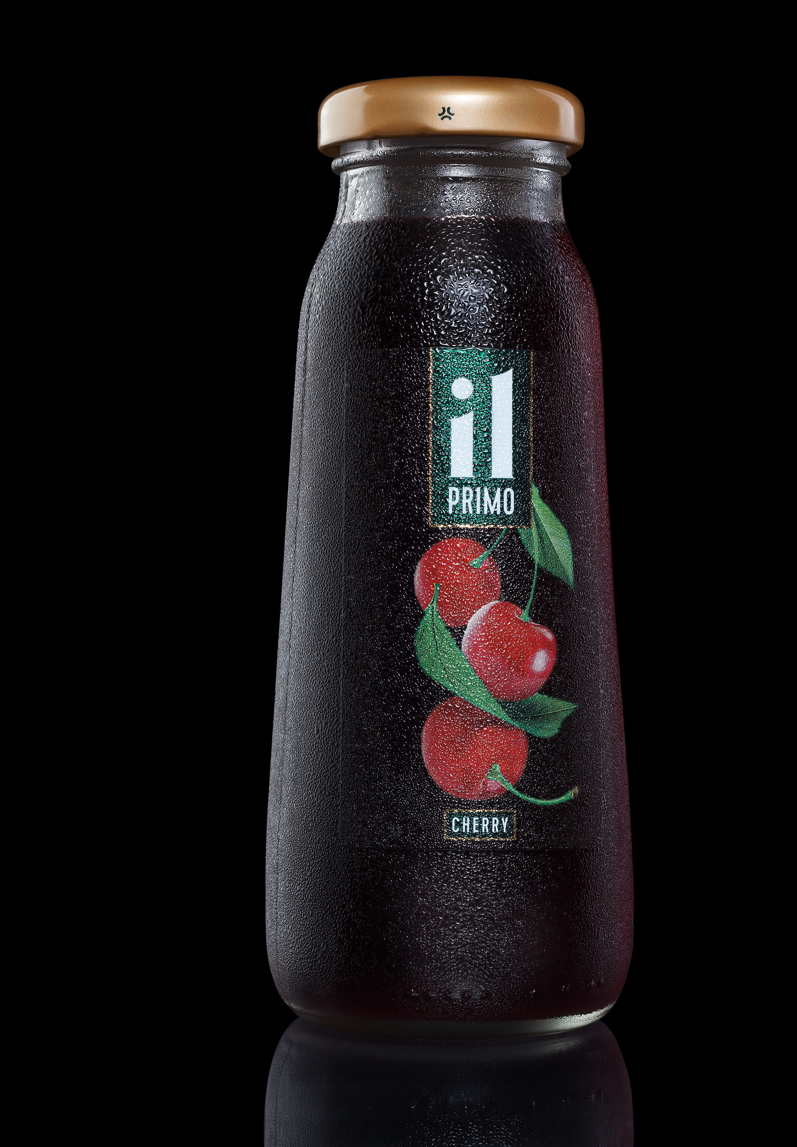 Сок вишня в стеклянной бутылке чёрный фон каталожное фото