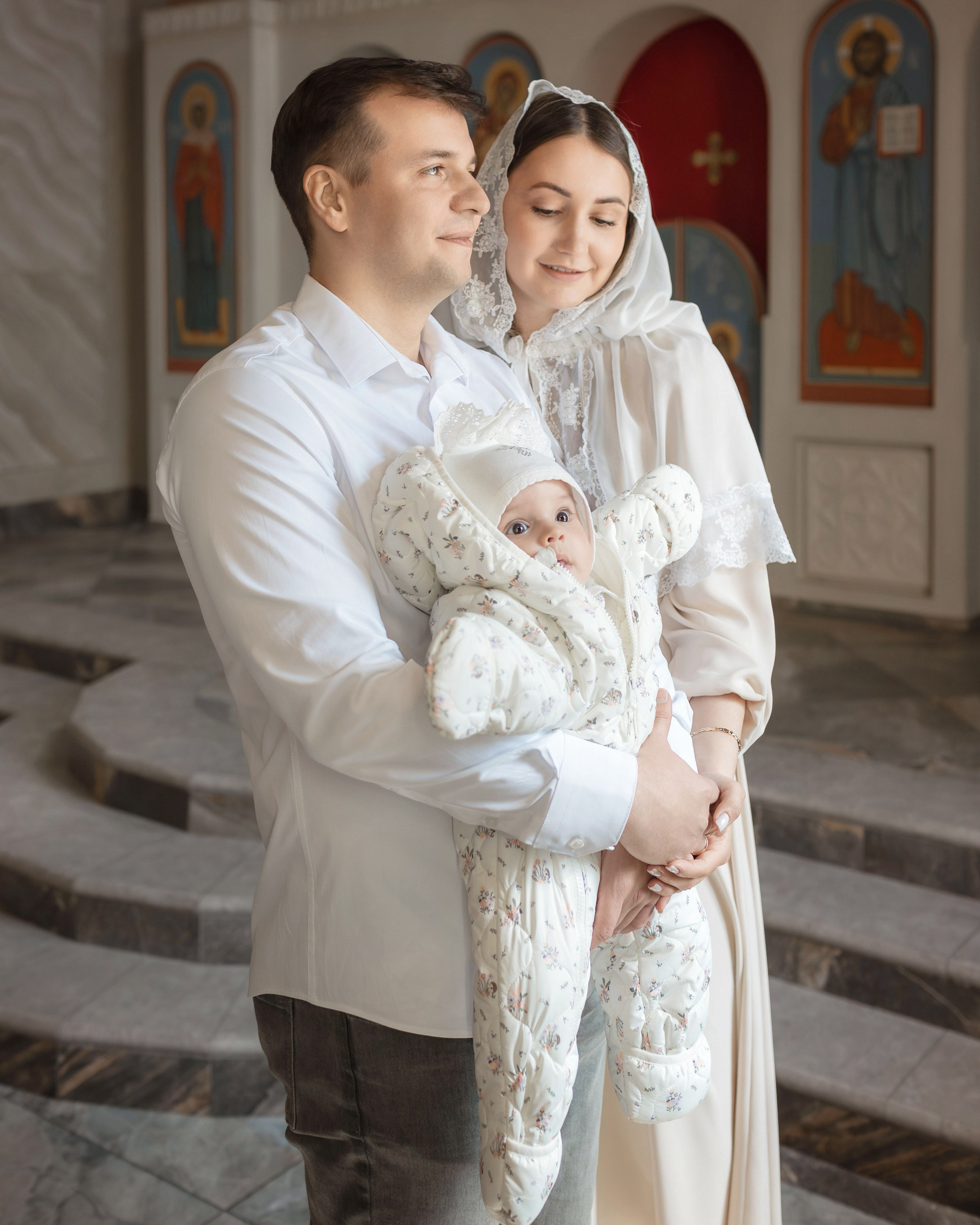 Родители с ребёнком после Таинства крещения в Троицке
