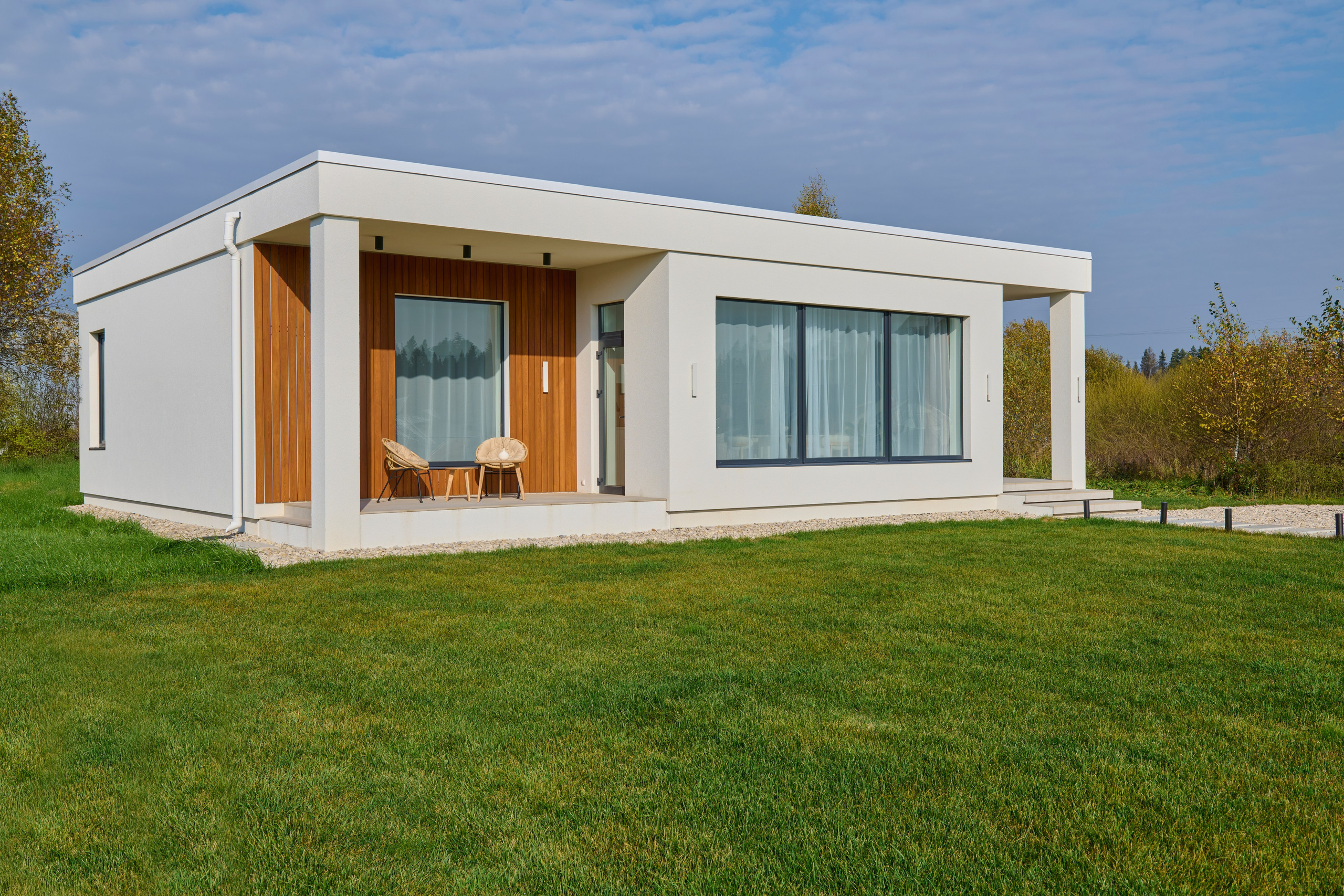 Экстерьер: одноэтажный дом, зелёный газон и деревянный портал