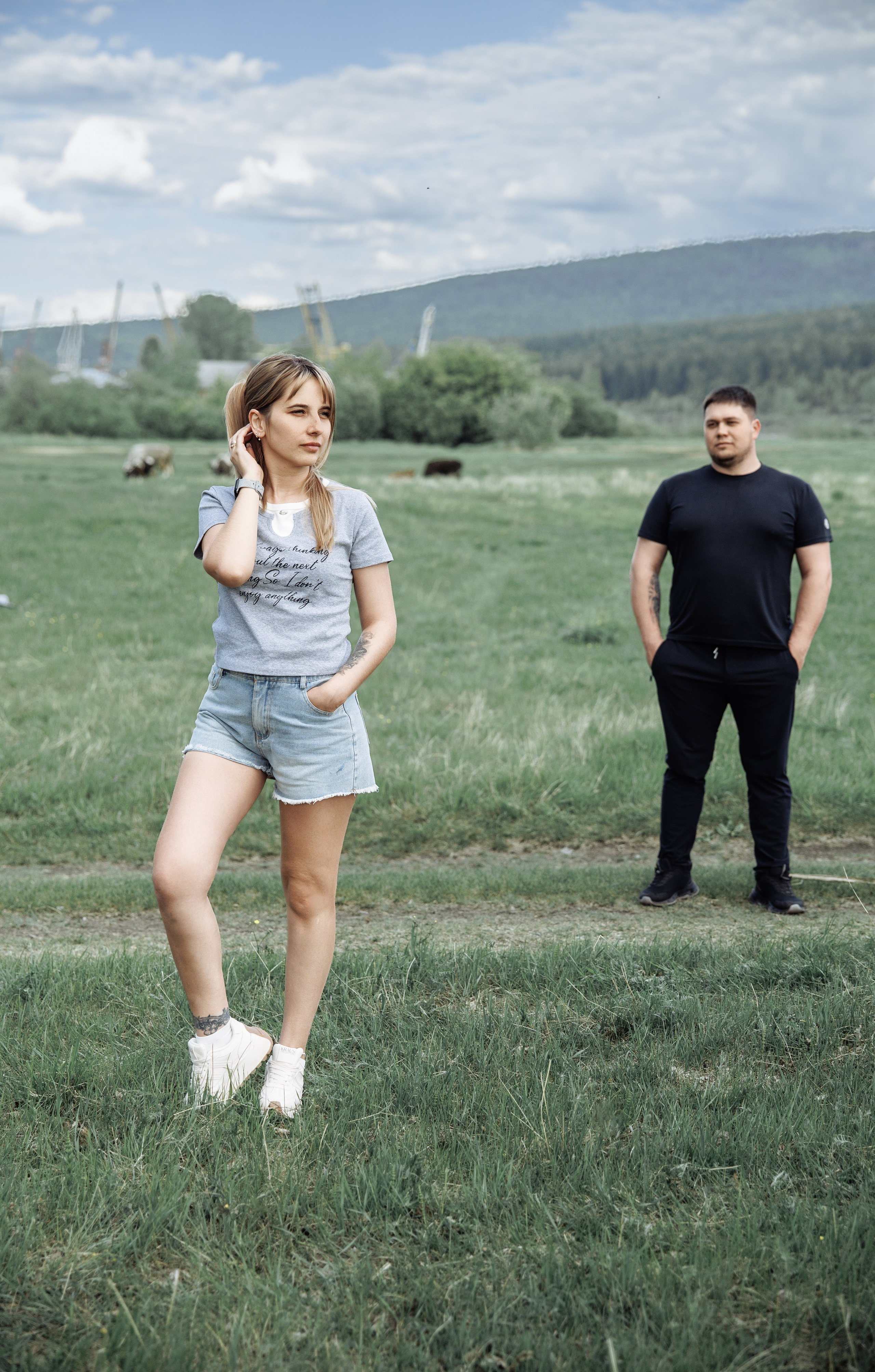 Девушка бежит по зелёному полю во время летней фотосессии на природе.
