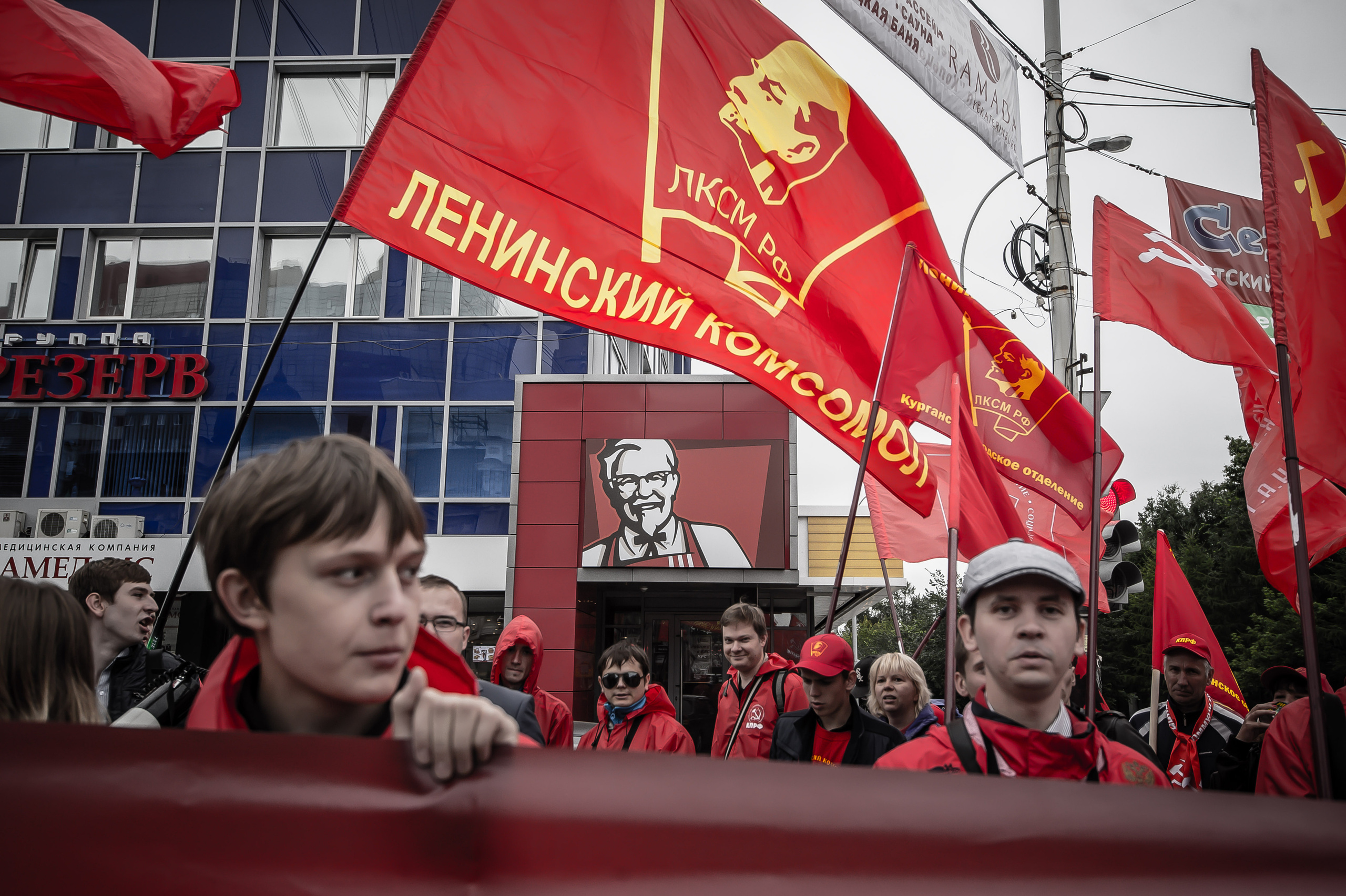 "ЗА НАМИ KFCила" из серии «У каждого своя икона» Молодые люди с флагом ленинского комсомола в центре Екатеринбурга проводят демонстрацию рядом с рестораном KFC Екатеринбург, 2014