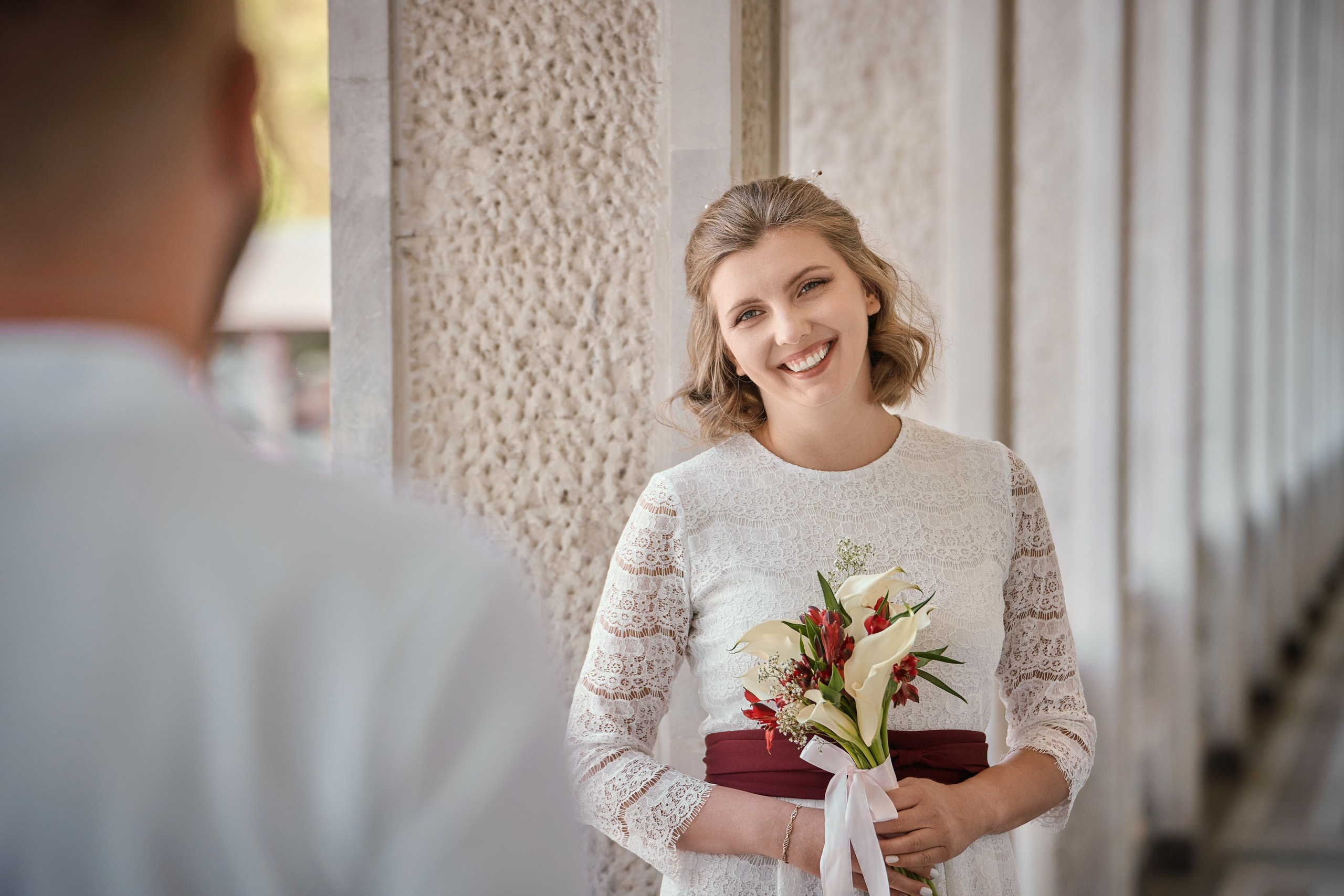 невеста с свадебным букетом смотрит на жениха