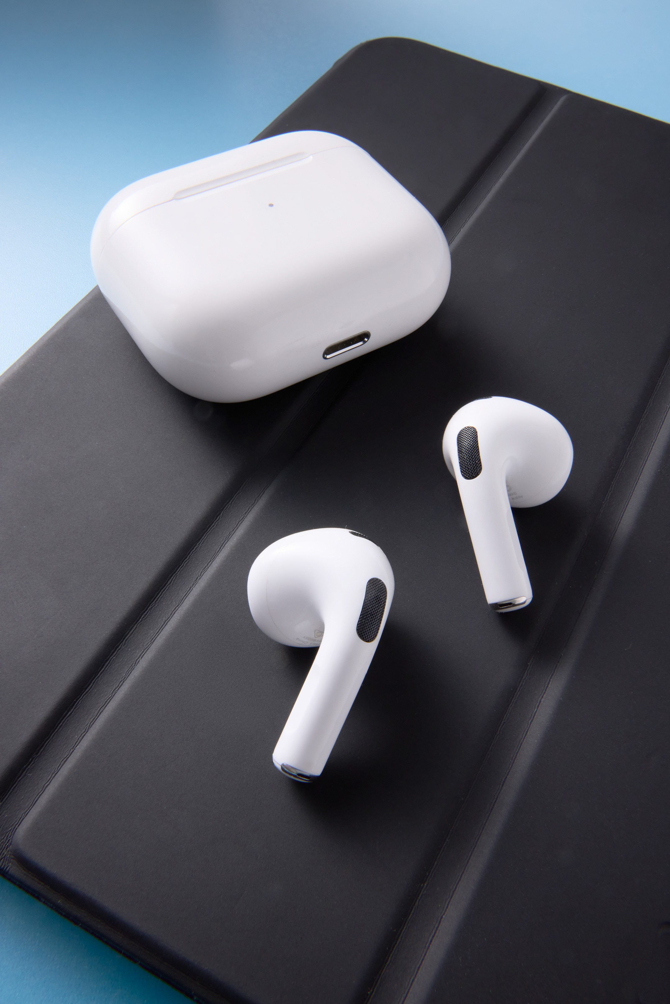 Apple AirPods on dark grey iPad cover - photographer Andrey Dunin