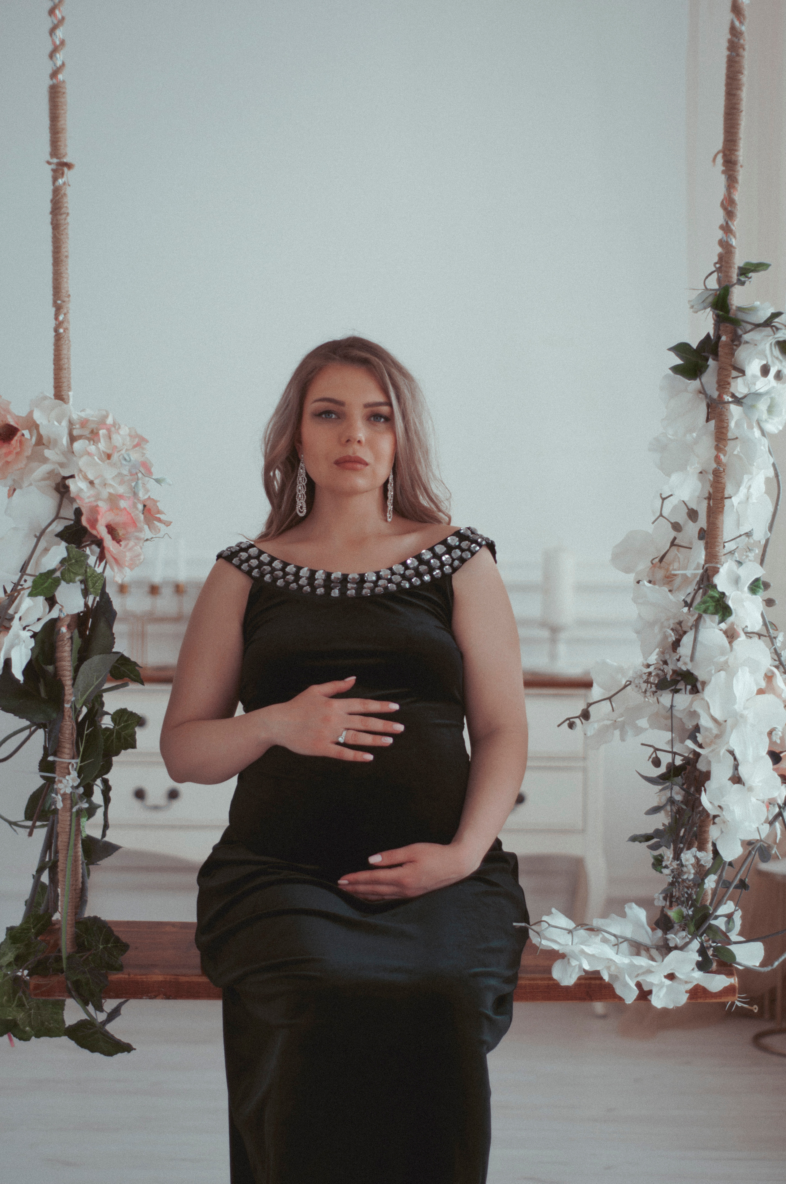 Беременная на качелях в фотостудии