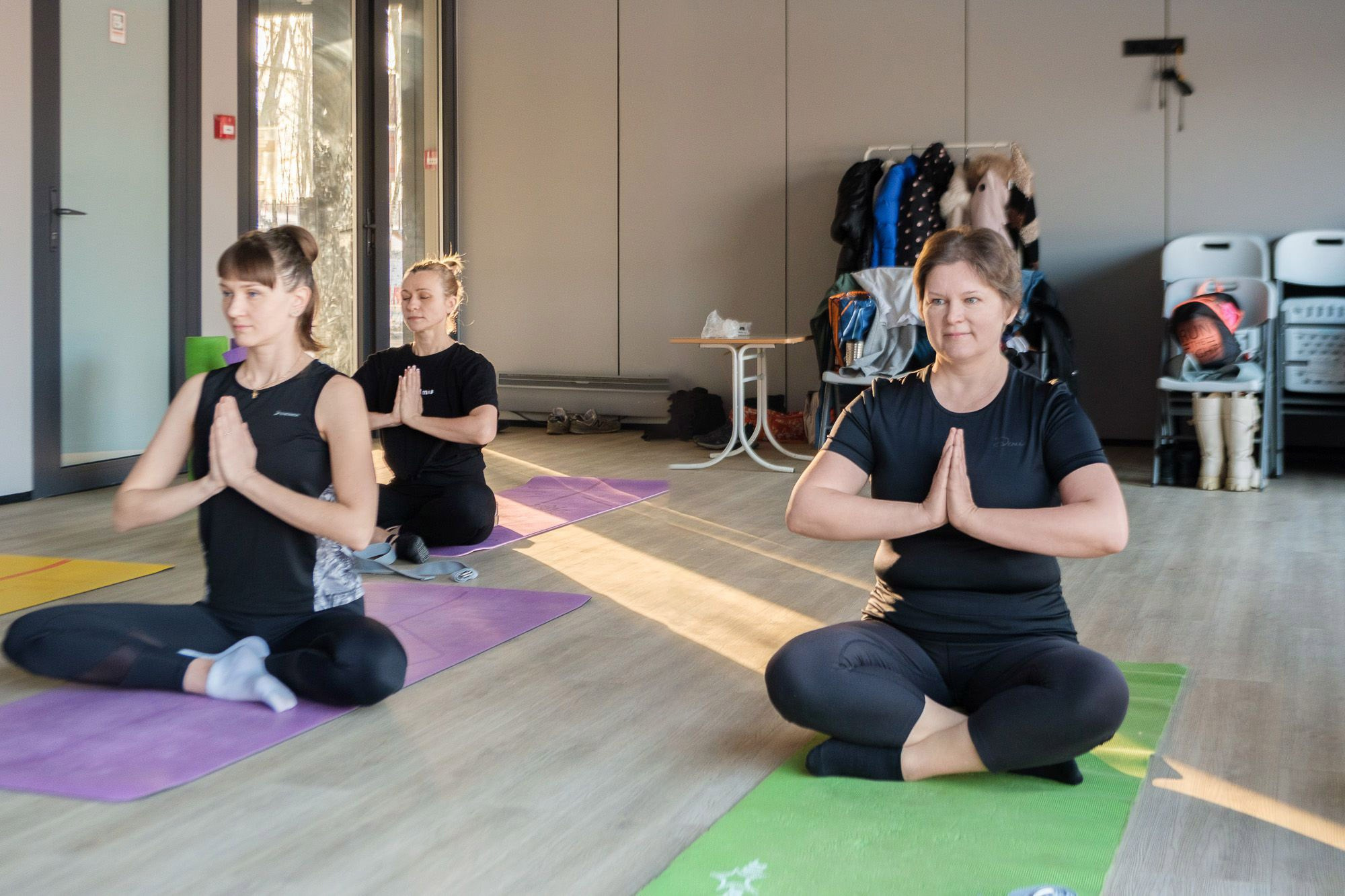 Йога со Светланой Банакиной Девушка в чёрной футболке в позе лотоса г.Электросталь стадион "Авангард"