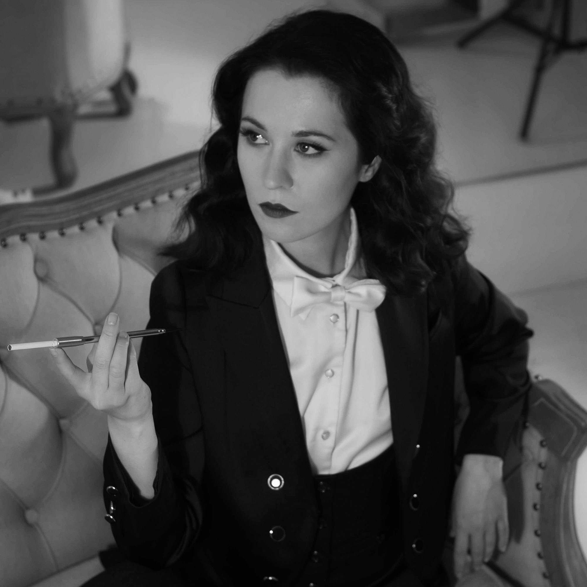 Фотосессия в винтажном стиле. Девушка в мужском костюме, с мундштуком. Черно-белый портрет, вид сверху.