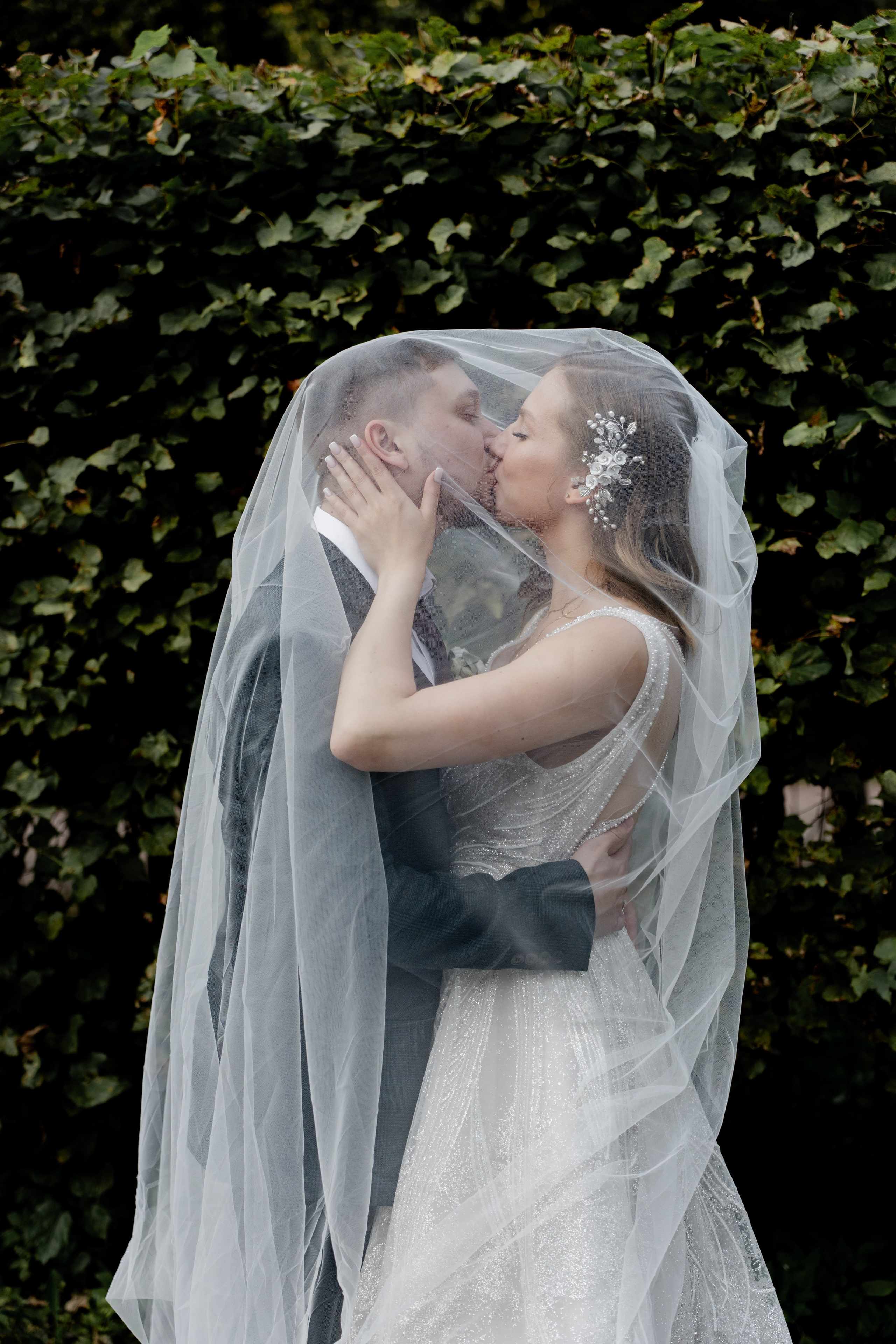 Невеста с женихом целуются под фатой. Свадебная фотосессия Москва