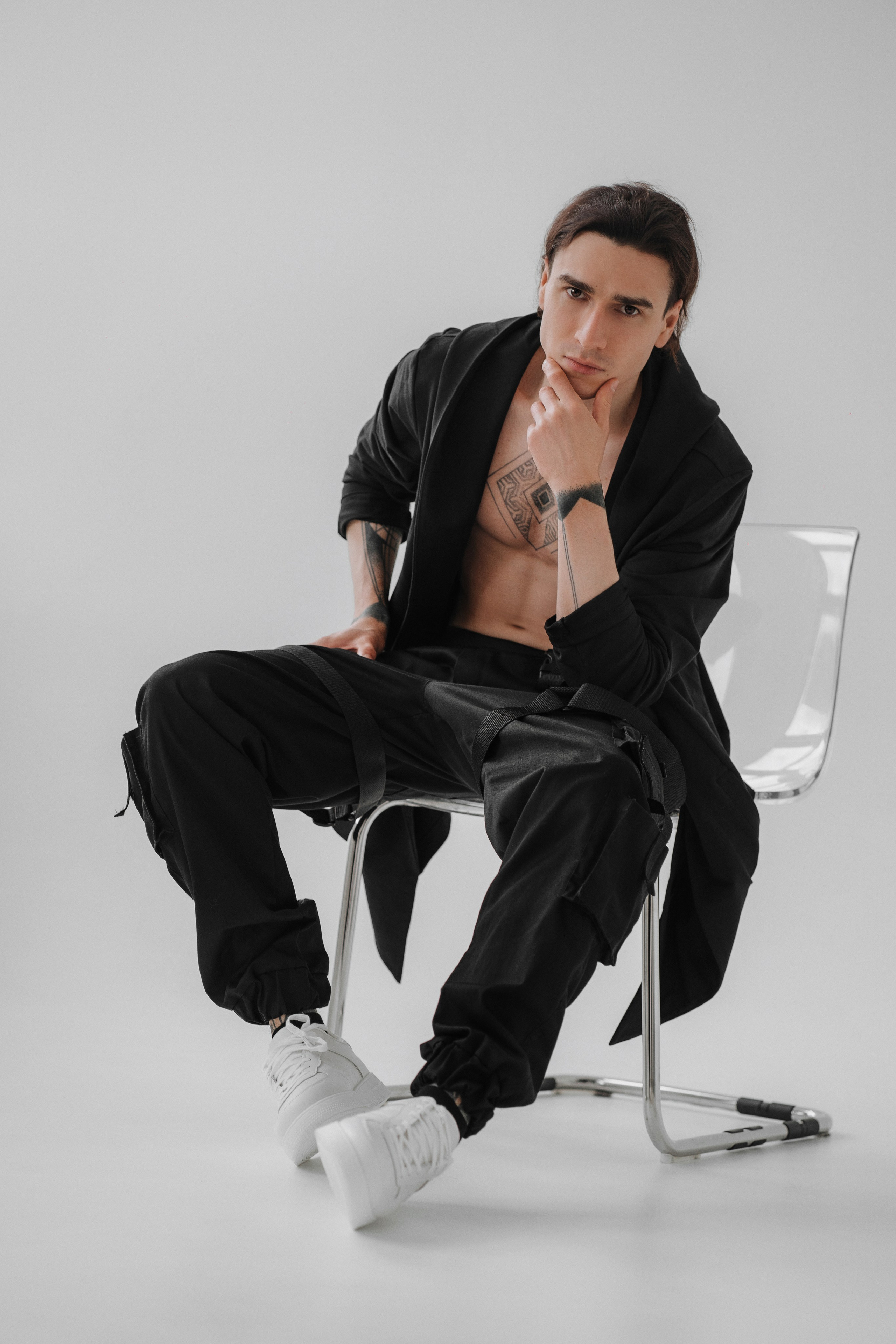 Модельное фото, мужчина в черном, сидит на стуле