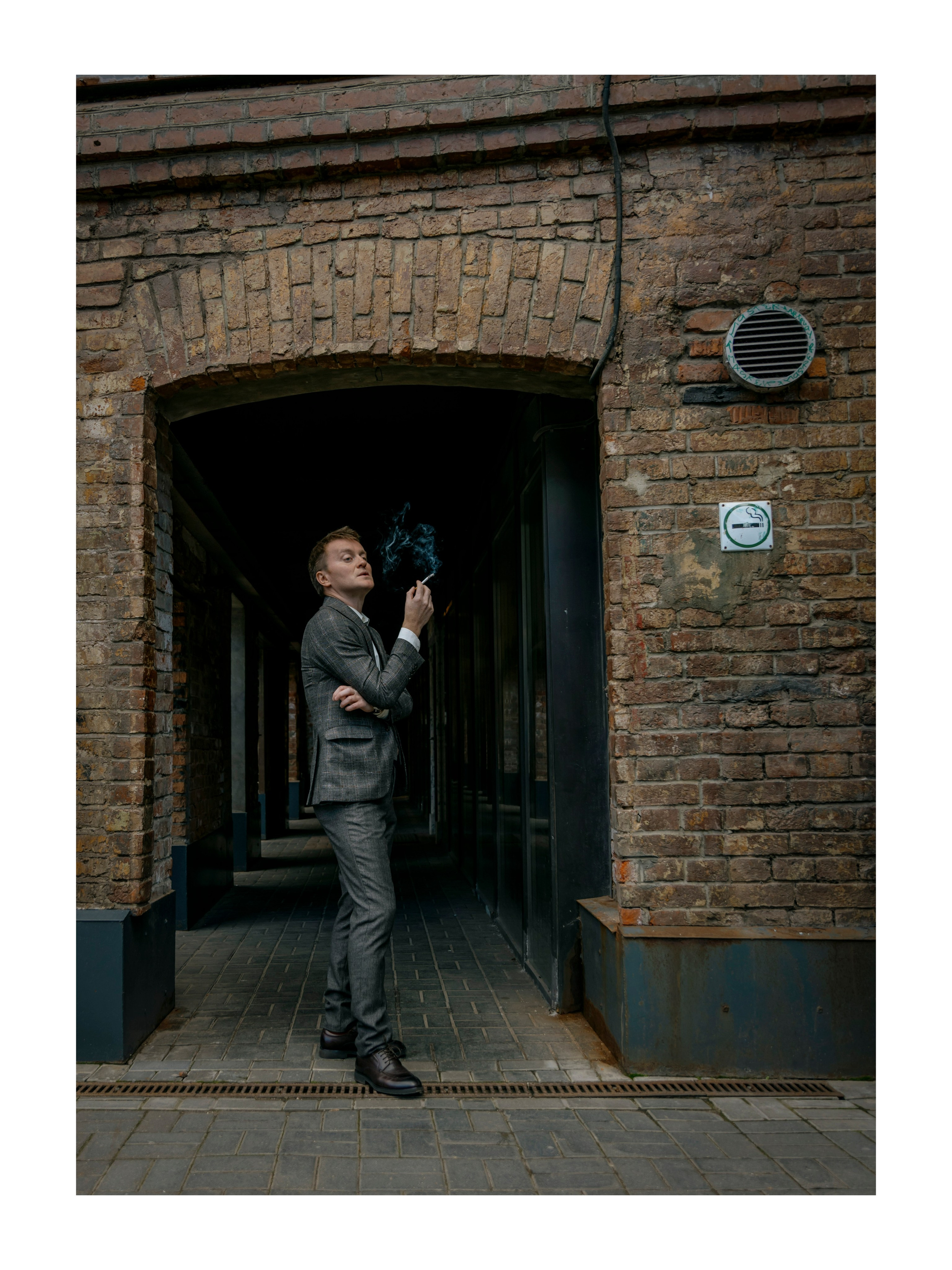мужчина в арке курит