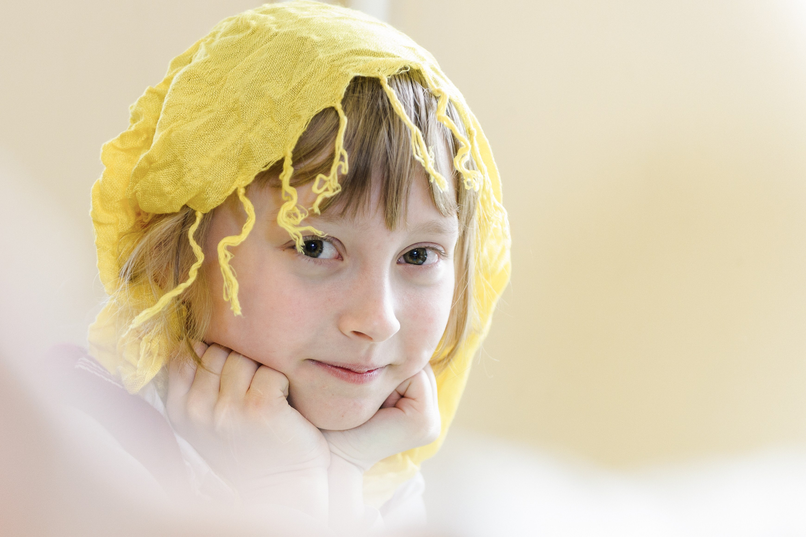 Девочка с жёлтым шарфом на голове крупным планом