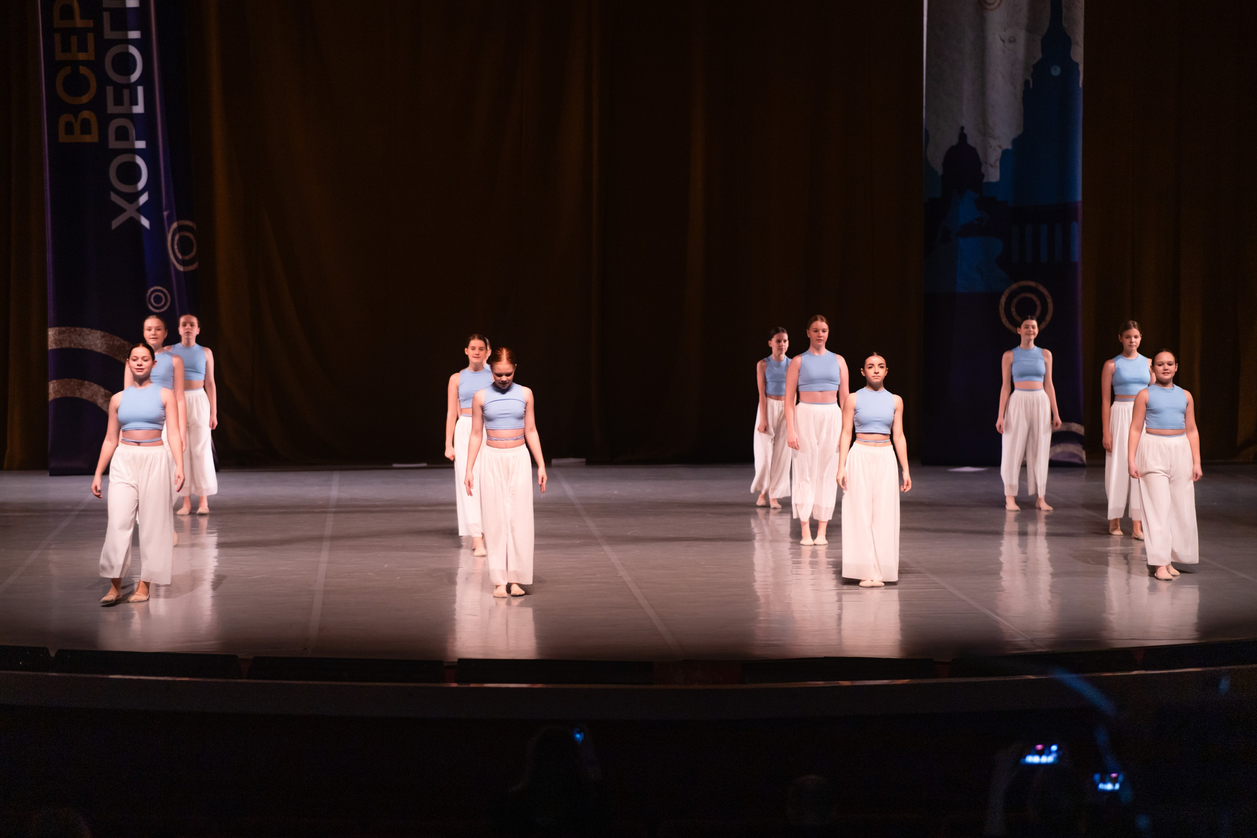 Широкоугольный кадр сцены: артисты занимают все пространство от кулисы до кулисы.