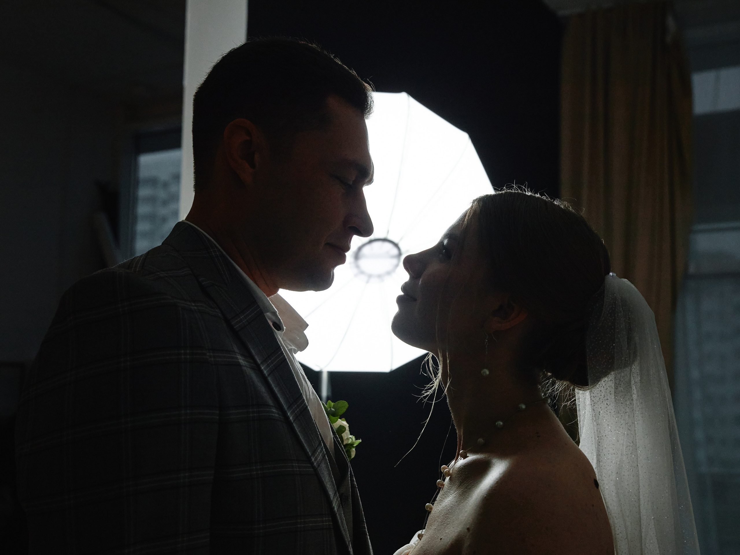 Силуэт жениха и невеста на фоне источника света