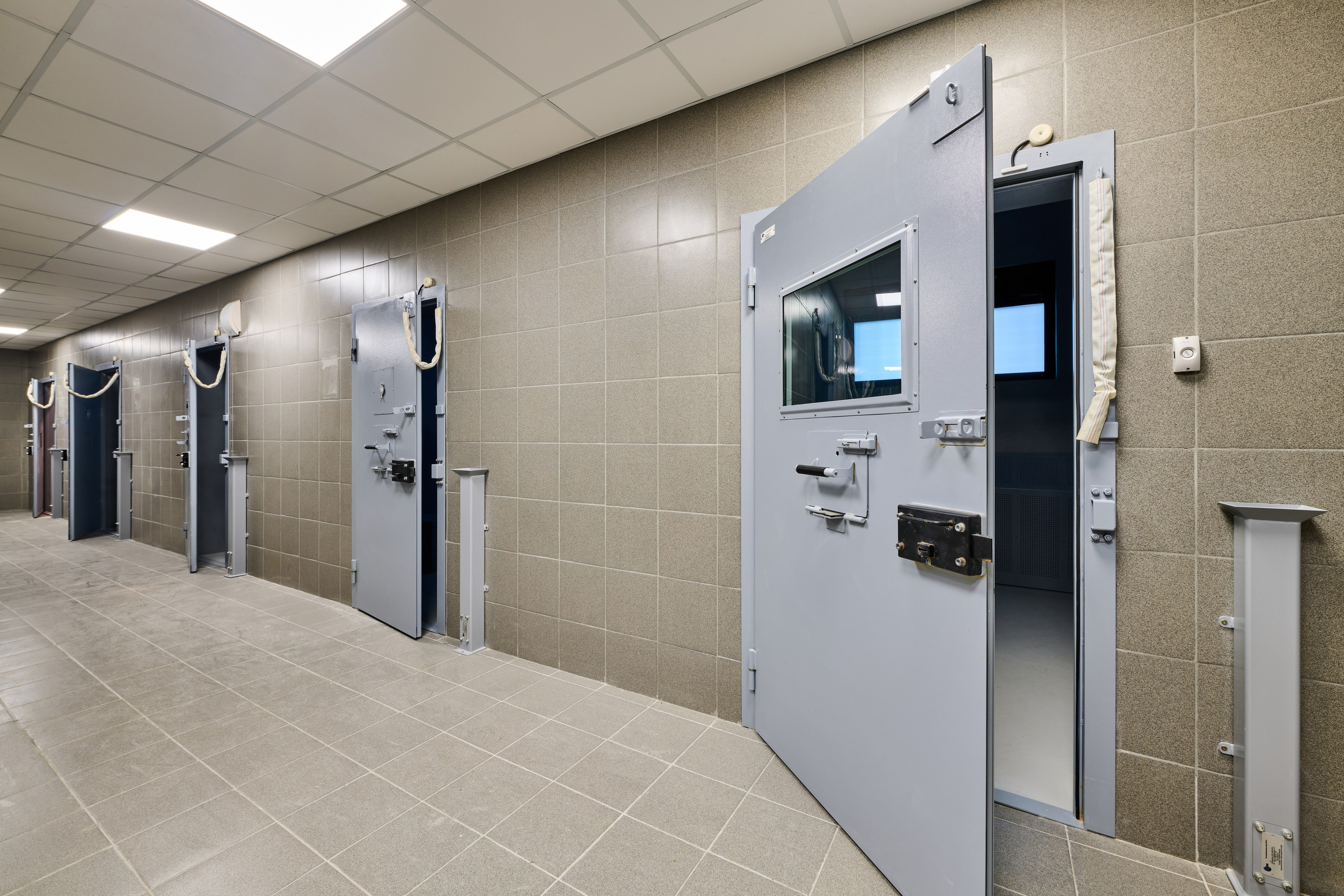 Коридор здания суда, усиленные серые двери со смотровыми окнами