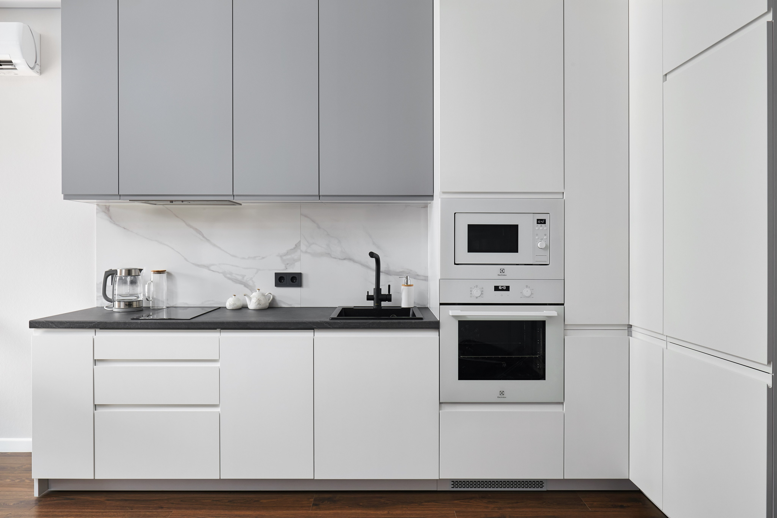 Аккуратный кухонный гарнитур светло-серый с белым 