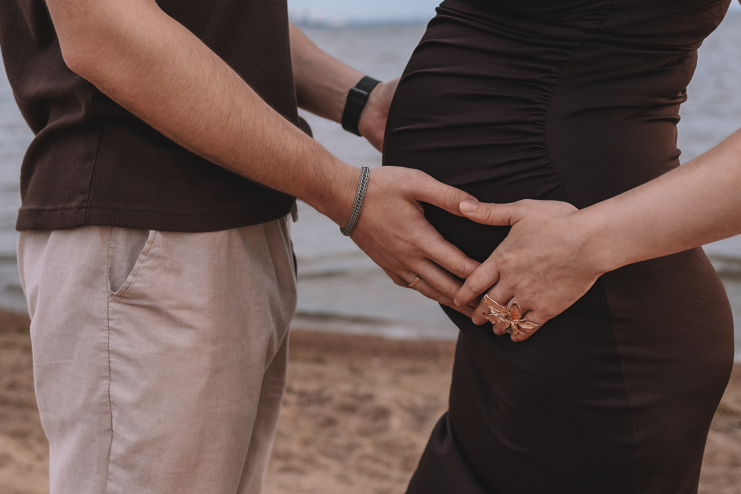 Руки пары на животе беременной, крупный план