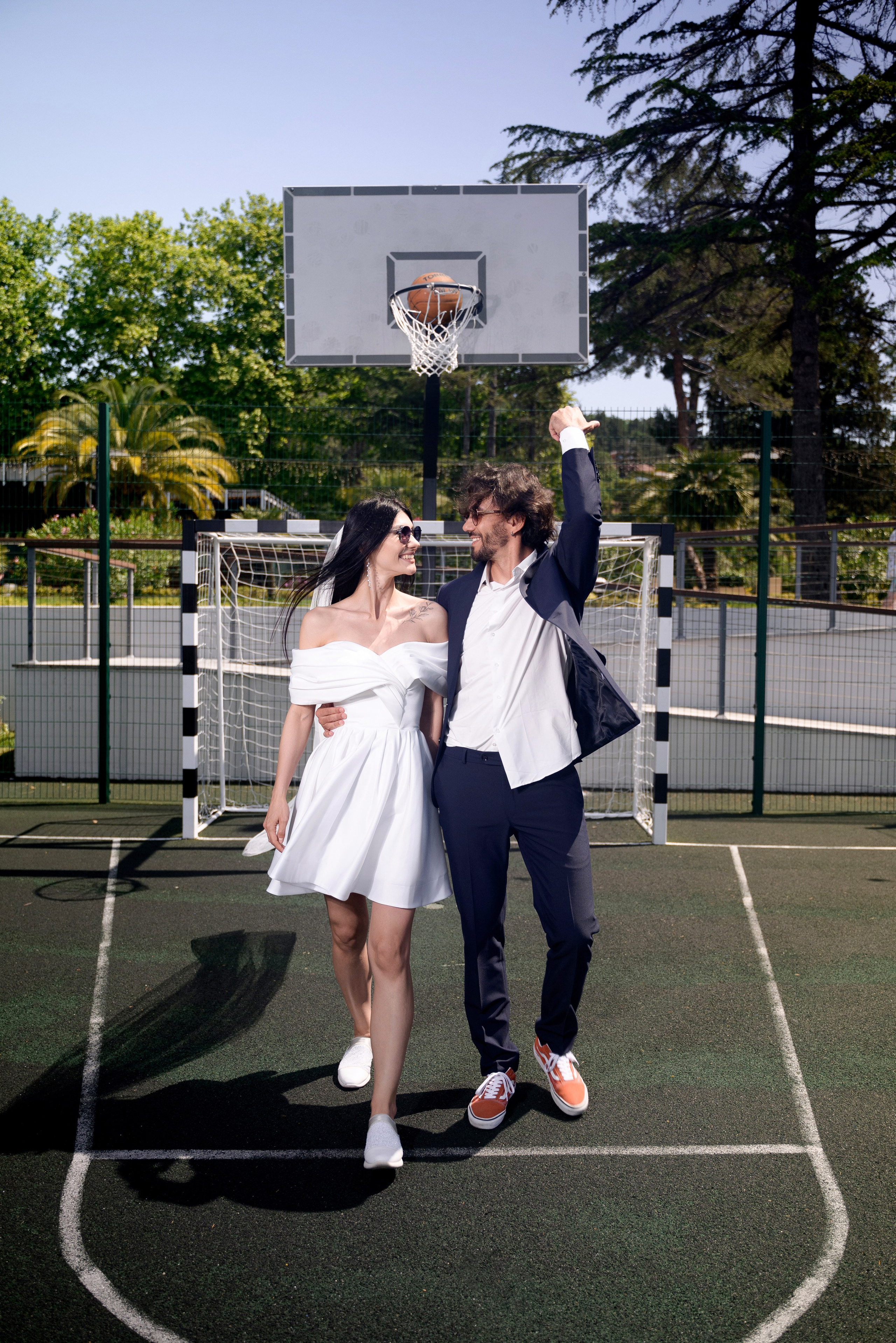 Свадебные фотографии в Сочи, наполненные счастьем и нежностью на баскетбольной площадке где жених бросает мяч не глядя в кольцо и попадает