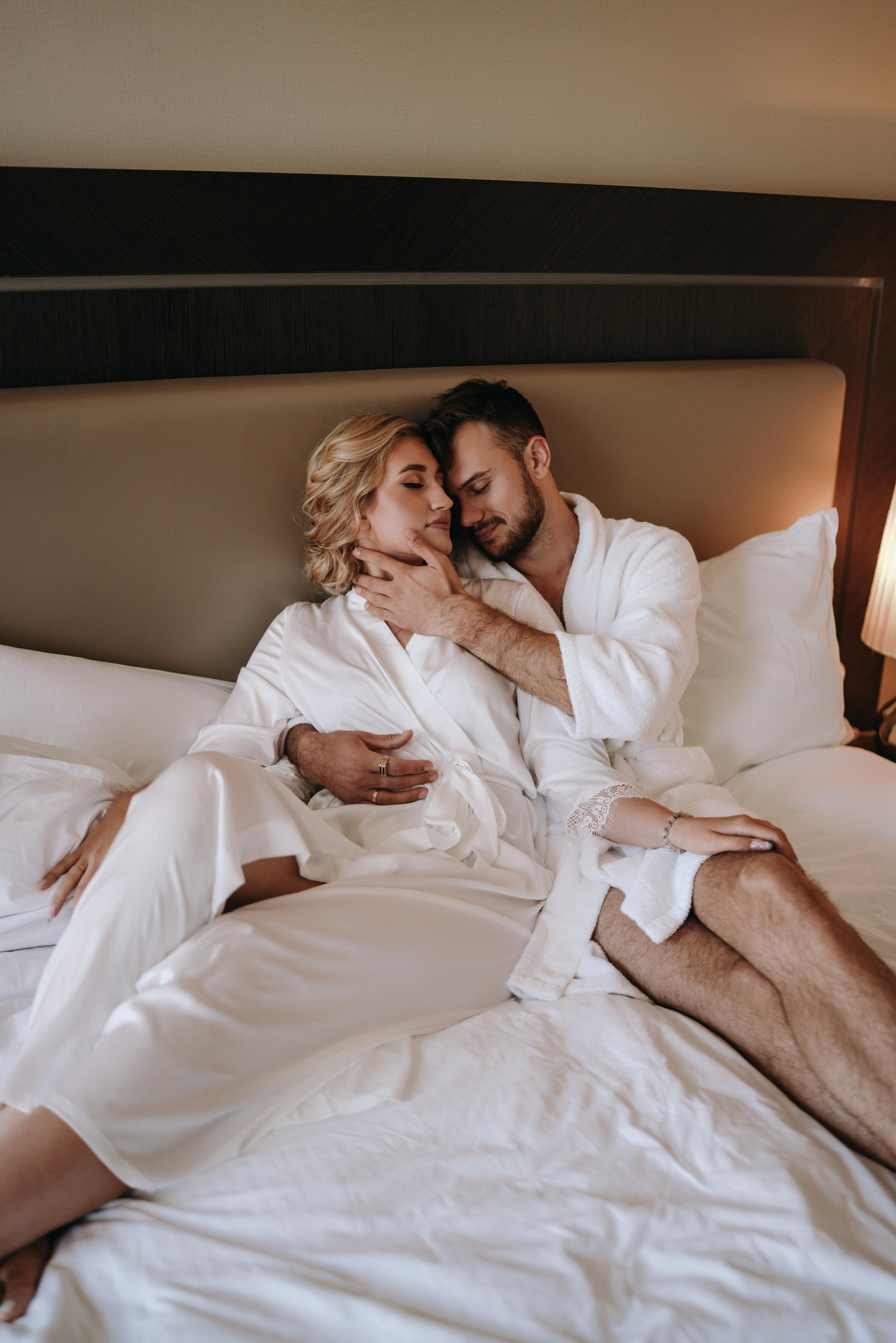 Сборы жениха и невесты гостиннице в Sheraton (Шератон), пара лежит на кровати в стандартном номере отеля, лучшие позы для молодожен 