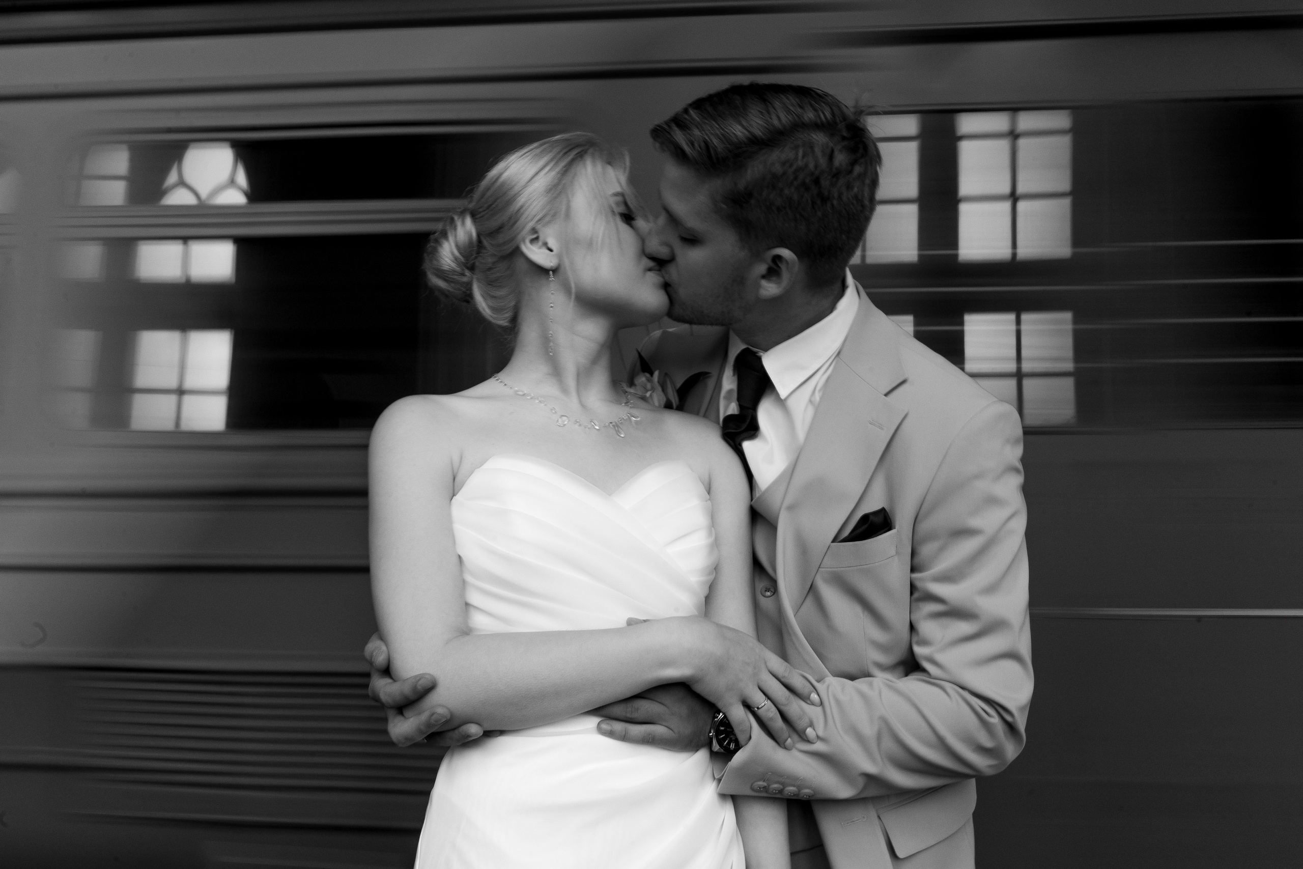 Свадьба в Санкт-Петербурге, фотосессия на прогулке, Крупный портрет невесты и жениха, обнимаются и целуются на вокзале в Павловске на фоне поезда.