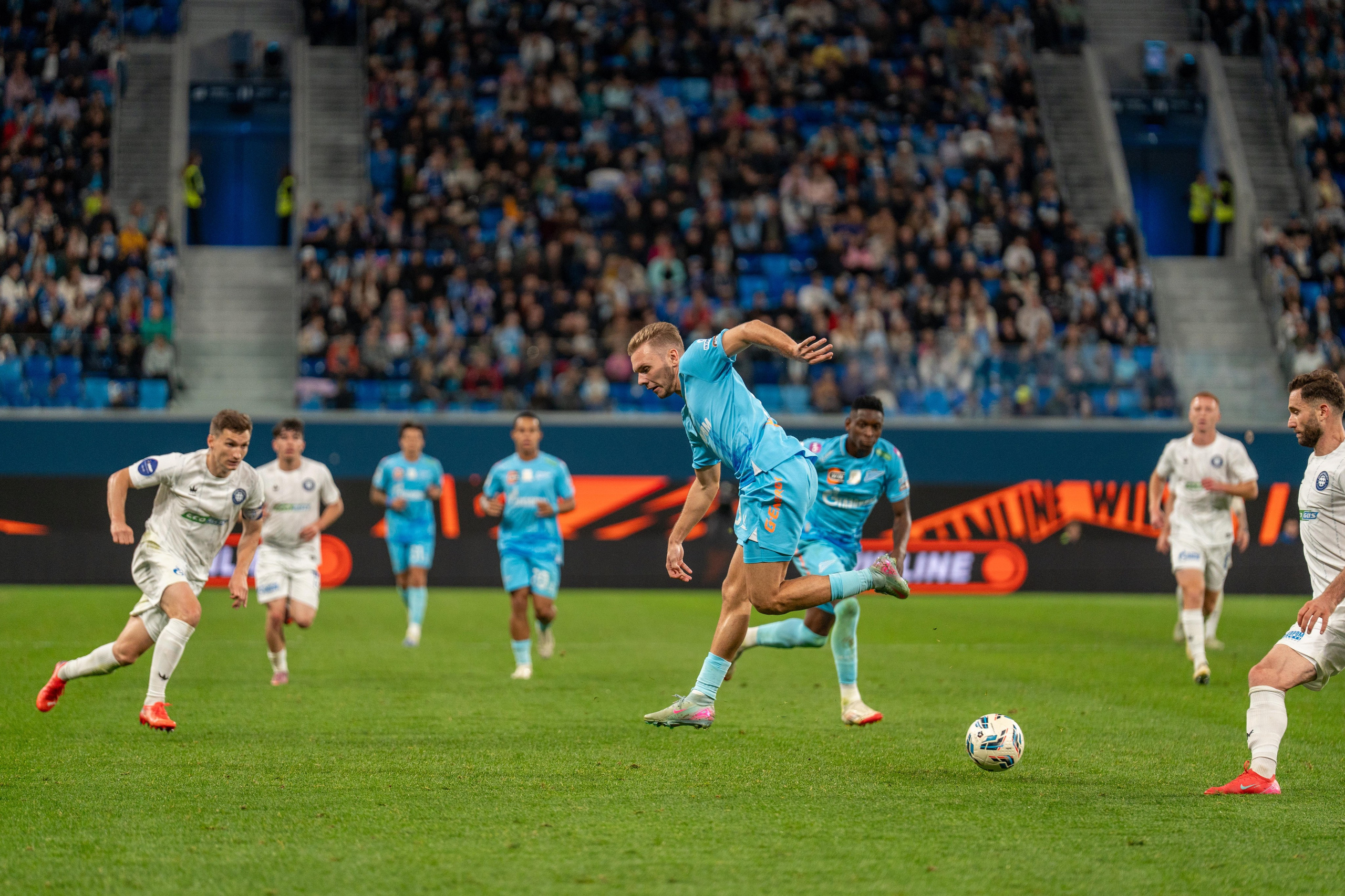 Нападающий Зенита в голубой форме бьет по воротам на Газпром Арене — спортивный фотограф Санкт-Петербург