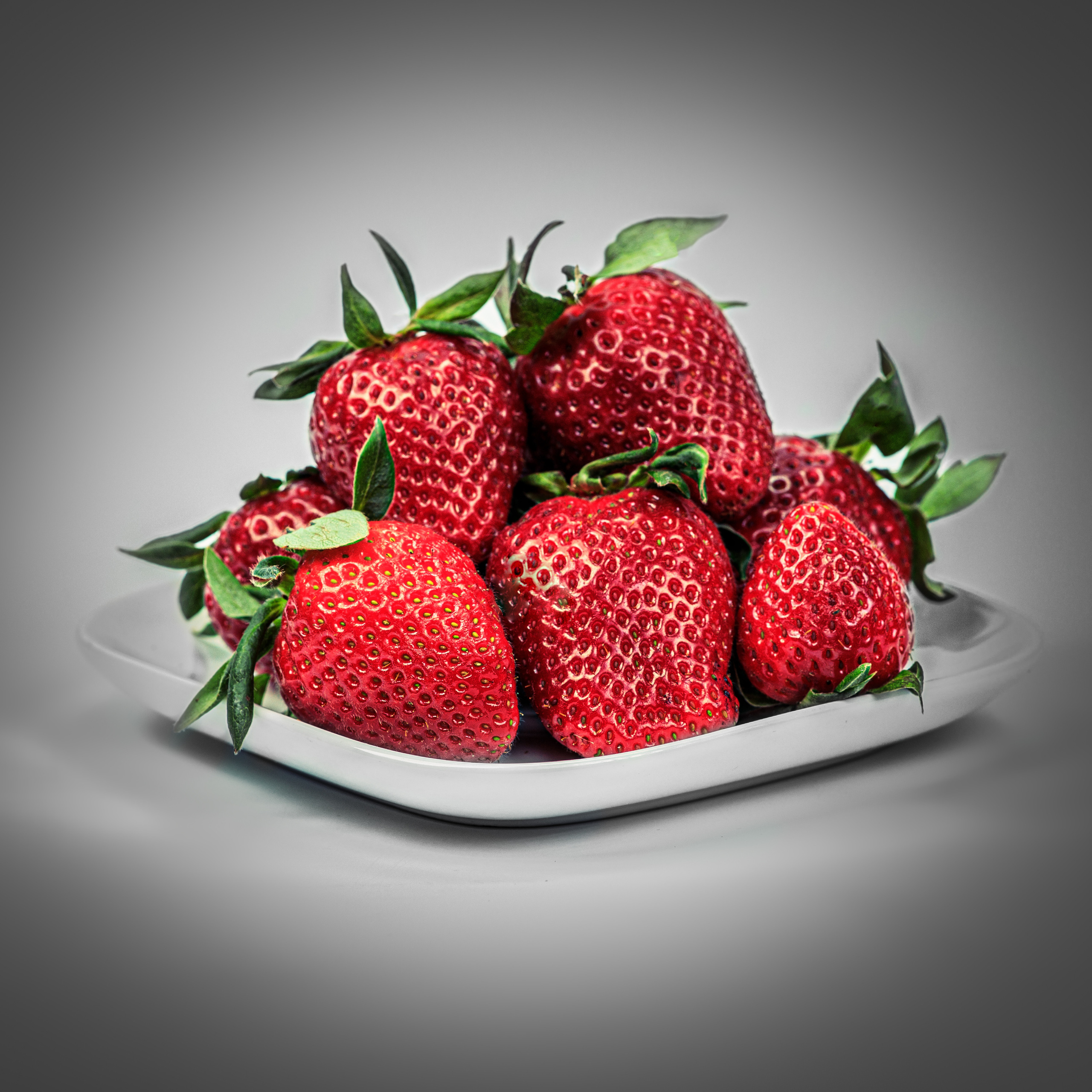 ягоды клубники на белой тарелке